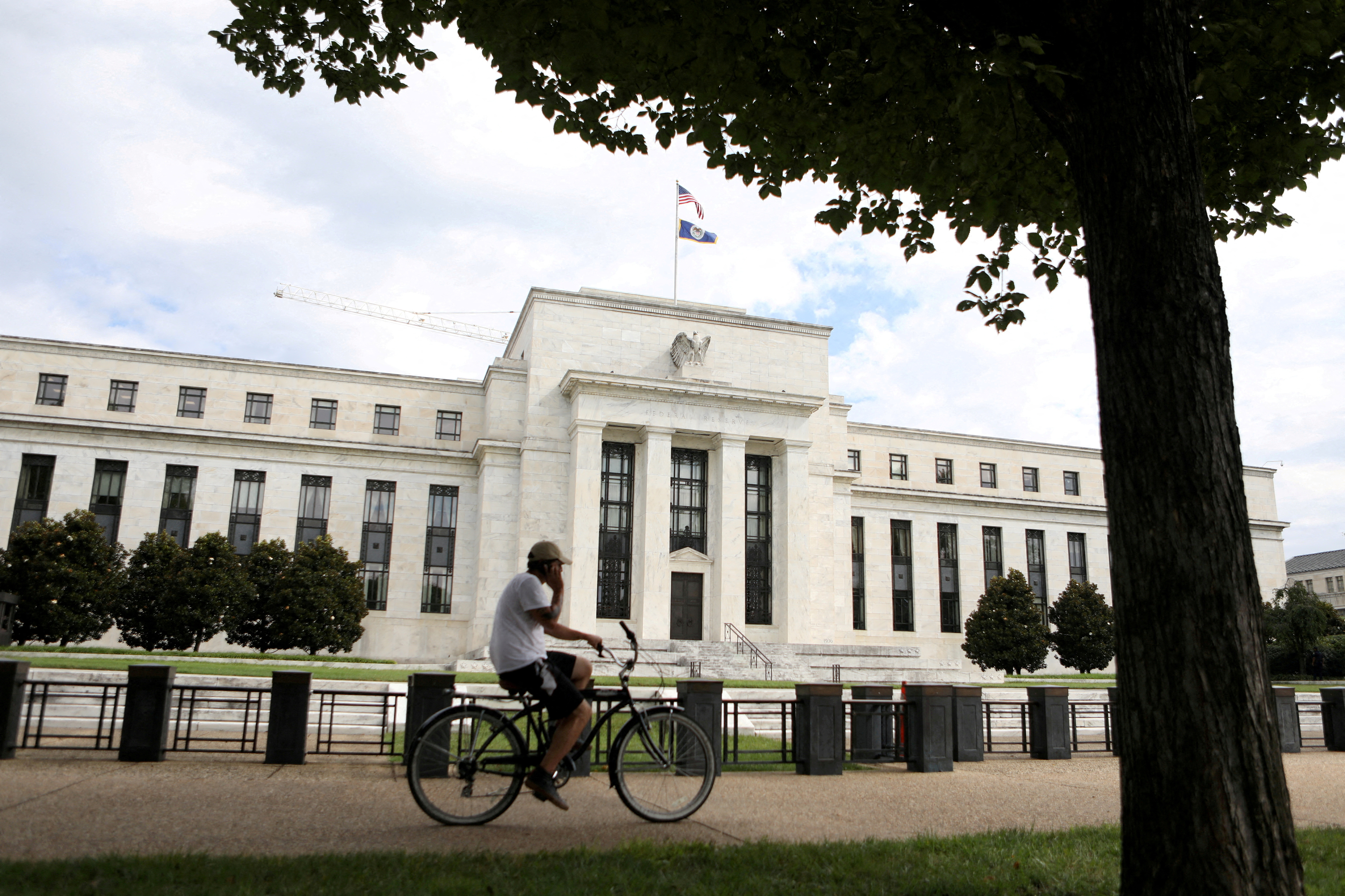 A cyclist passes the Federal Reserve building in Washington, DC