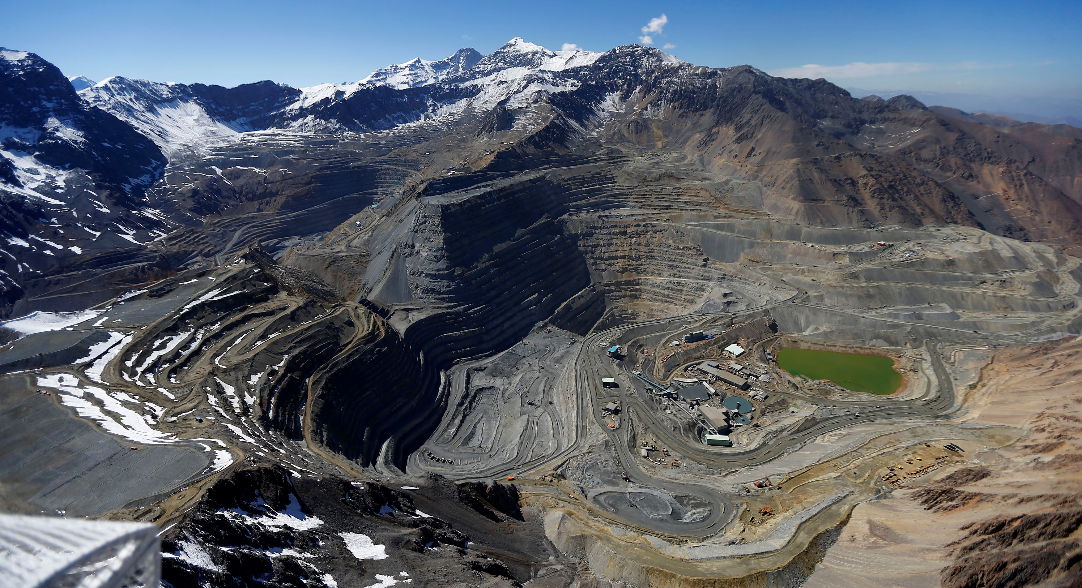 An aerial view of open pits of CODELCO's Andina and Anglo American's Los Bronces copper mines with Olivares glaciers in the background at Los Andes Mountain range