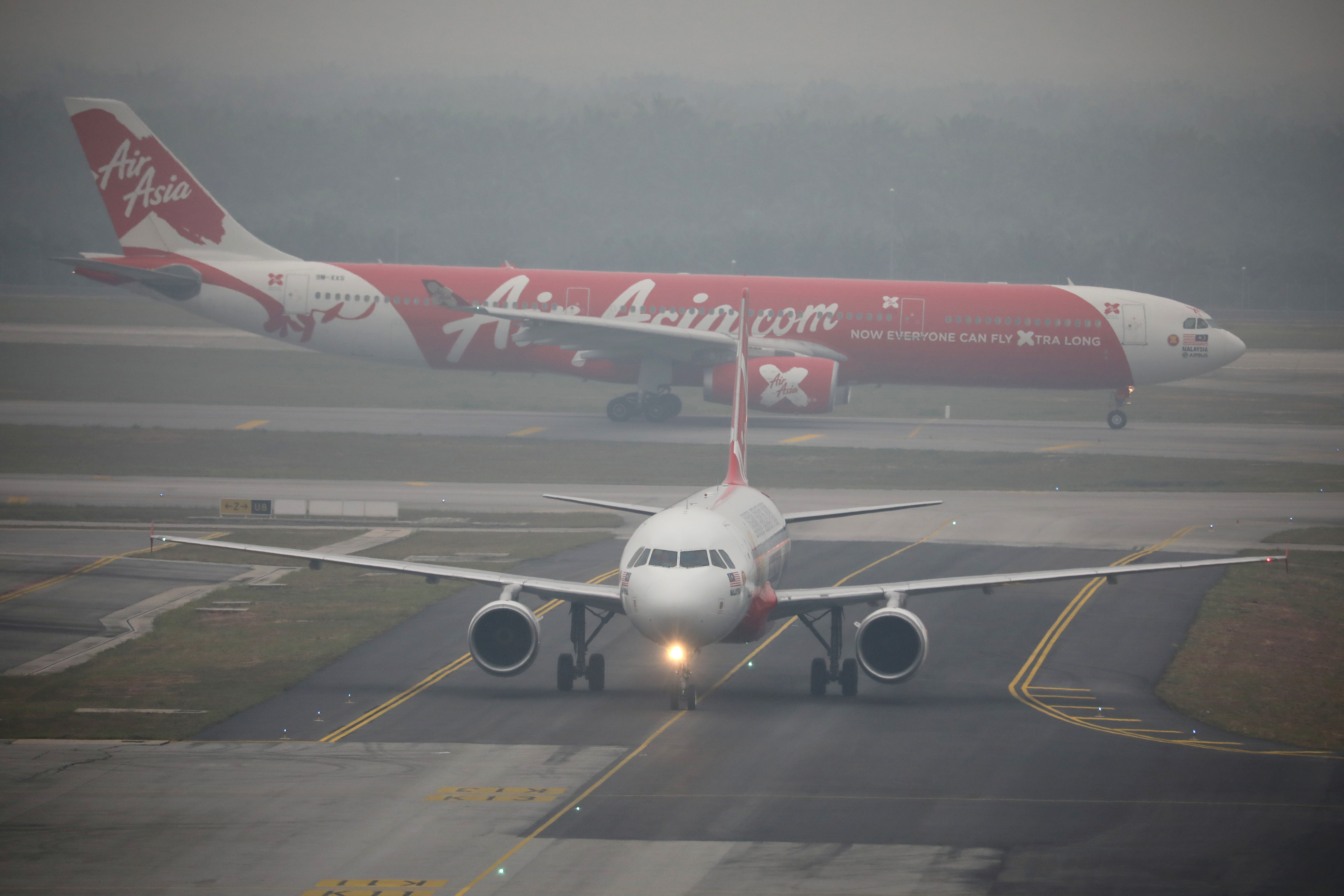 Air Asia airplanes are pictured on the haze-shrouded tarmac at Kuala Lumpur International Airport 2 in Sepang