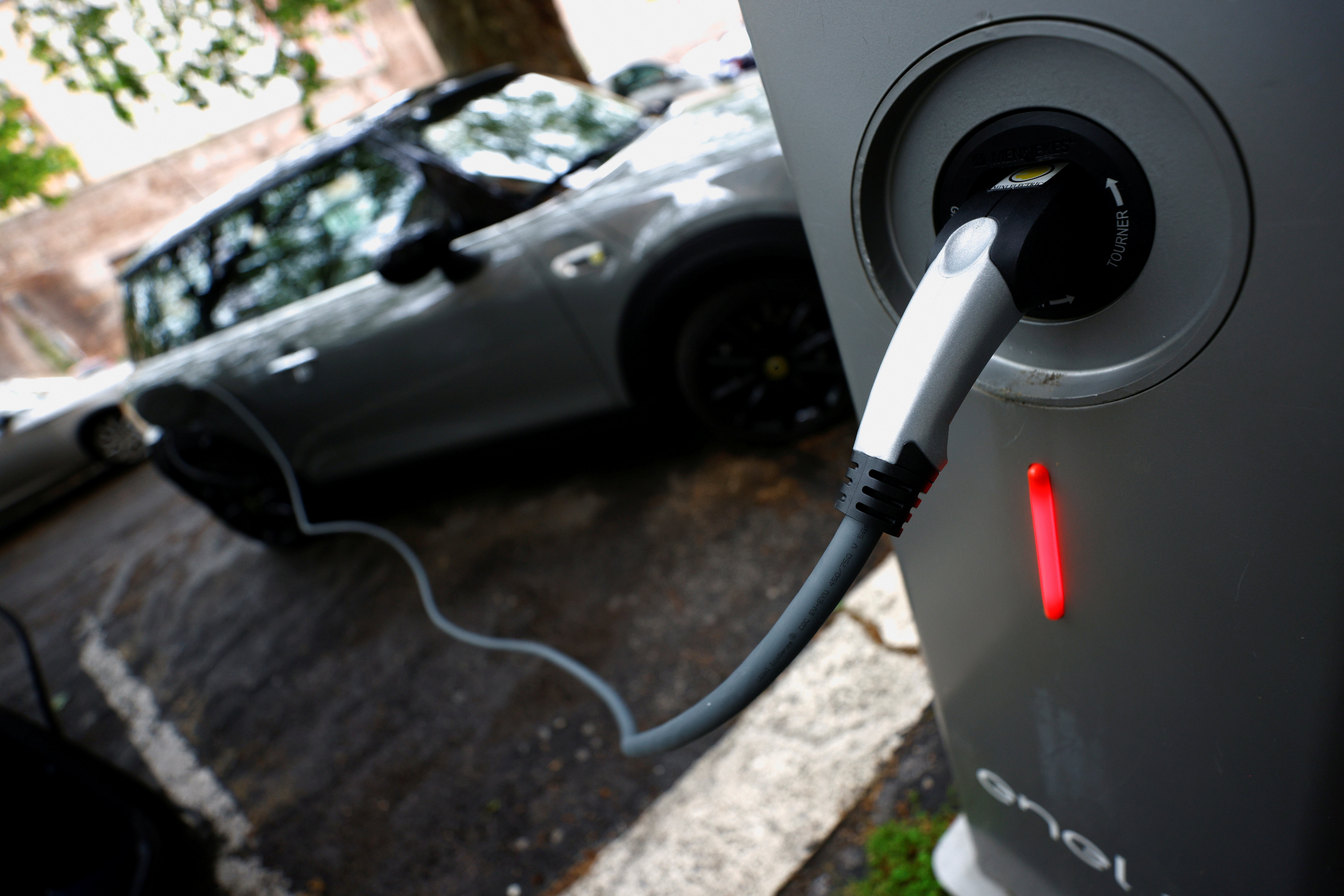 An electric car is seen plugged in at a charging point for electric vehicles in Rome, Italy, April 28, 2021. REUTERS/Guglielmo Mangiapane