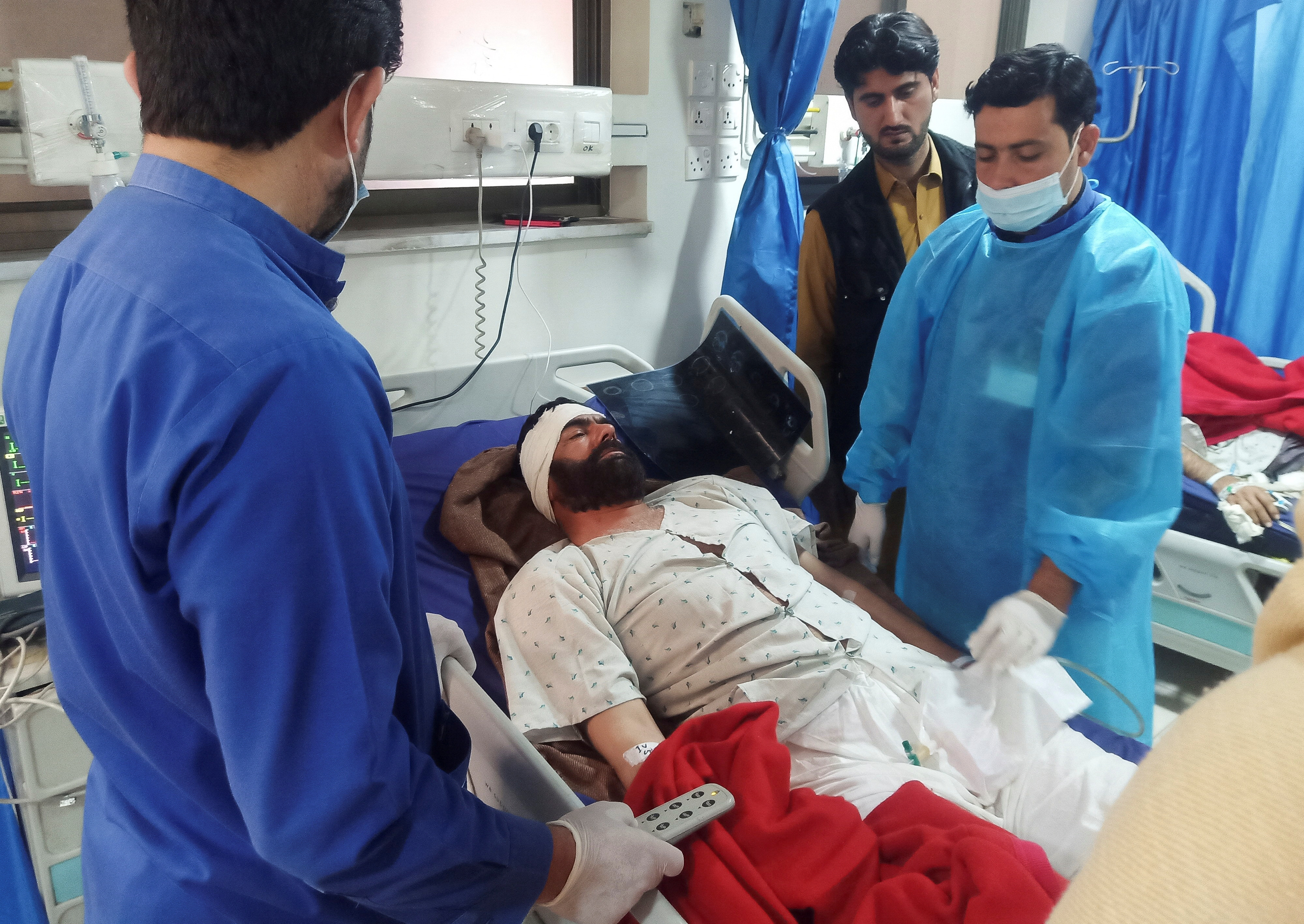 A man, who was injured after a suicide blast in a mosque, receives medical aid at a hospital in Peshawar