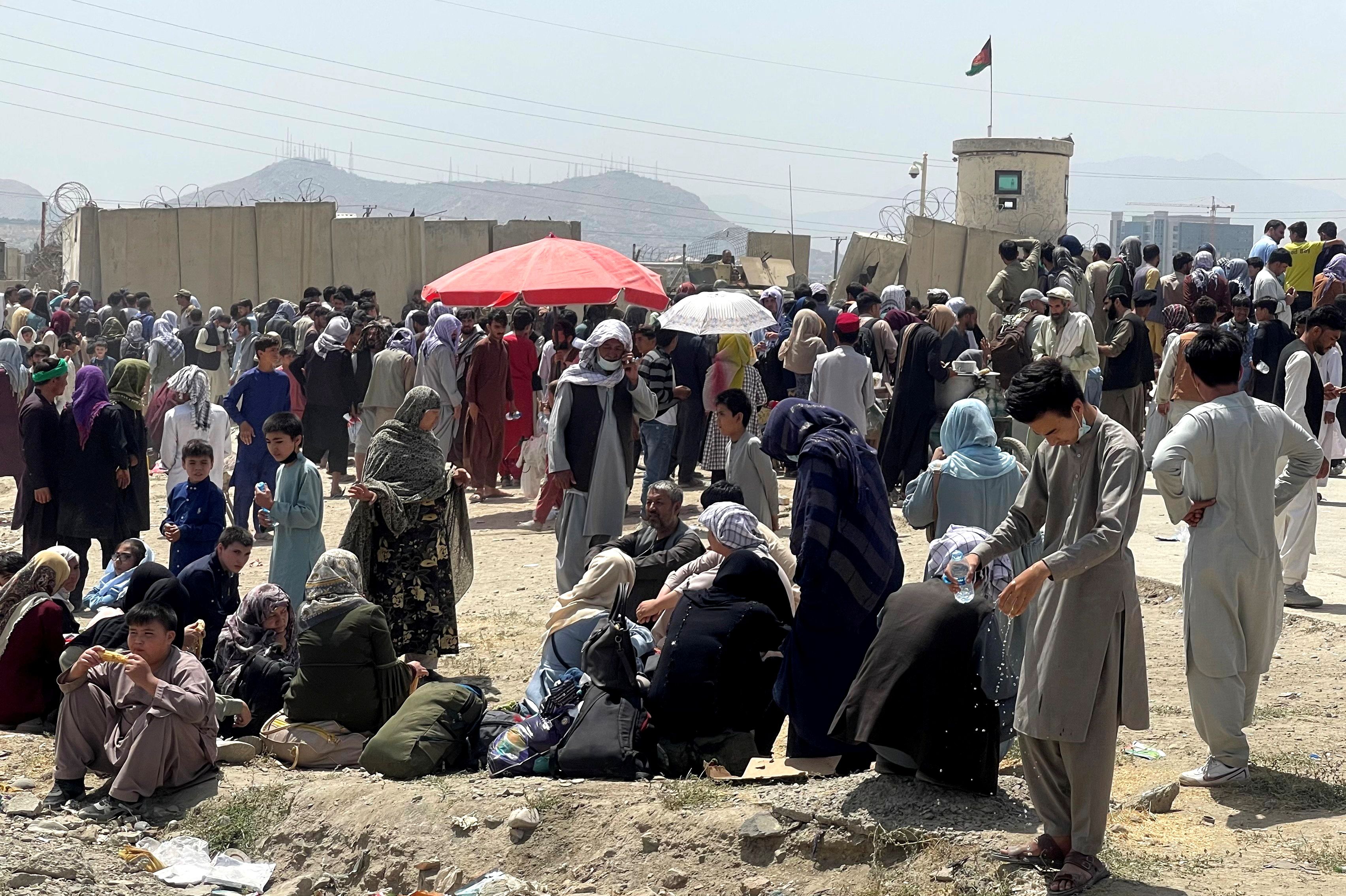 People wait outside Hamid Karzai International Airport in Kabul