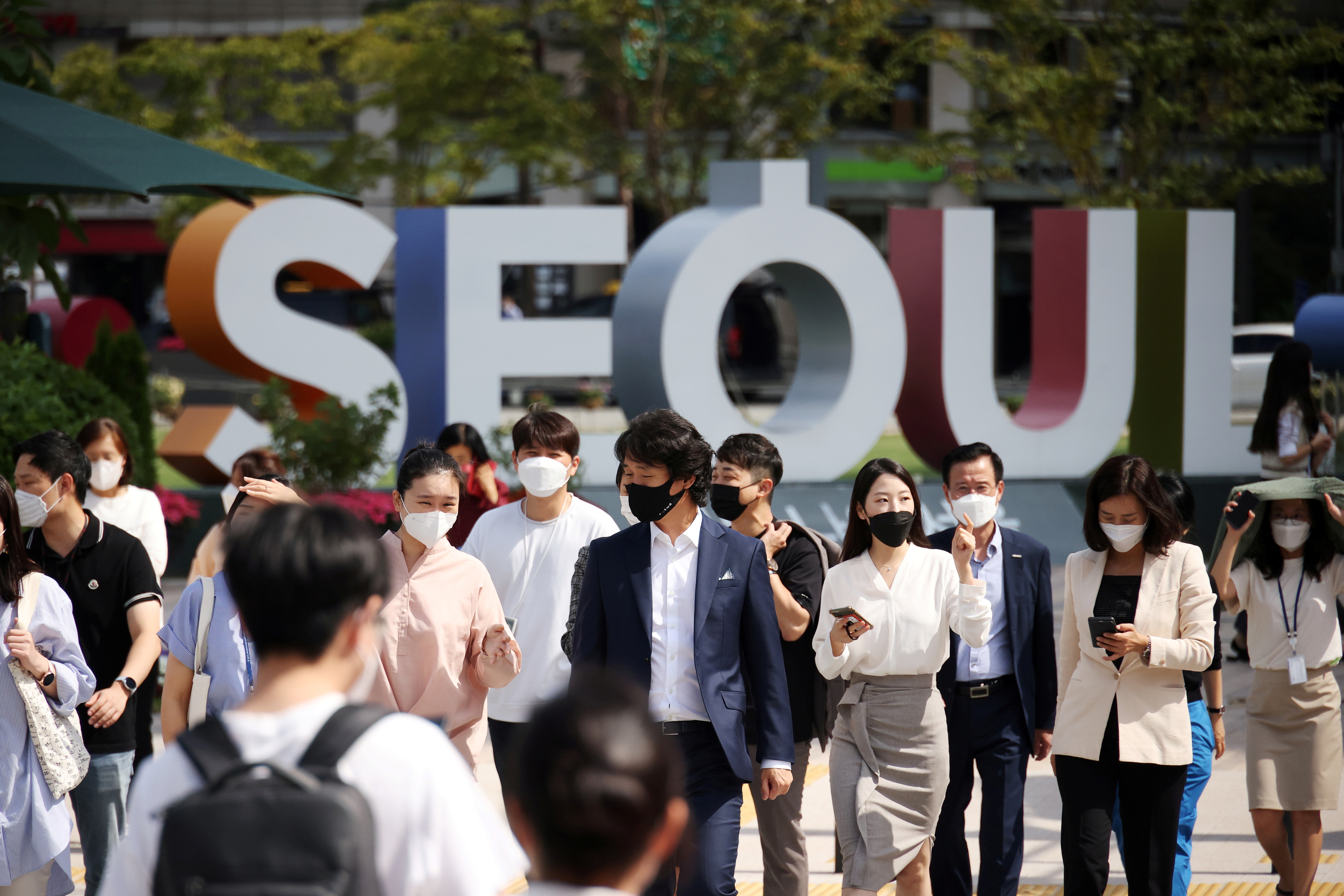 Commuters wearing masks to avoid contracting the coronavirus disease (COVID-19) walk on a zebra crossing in Seoul