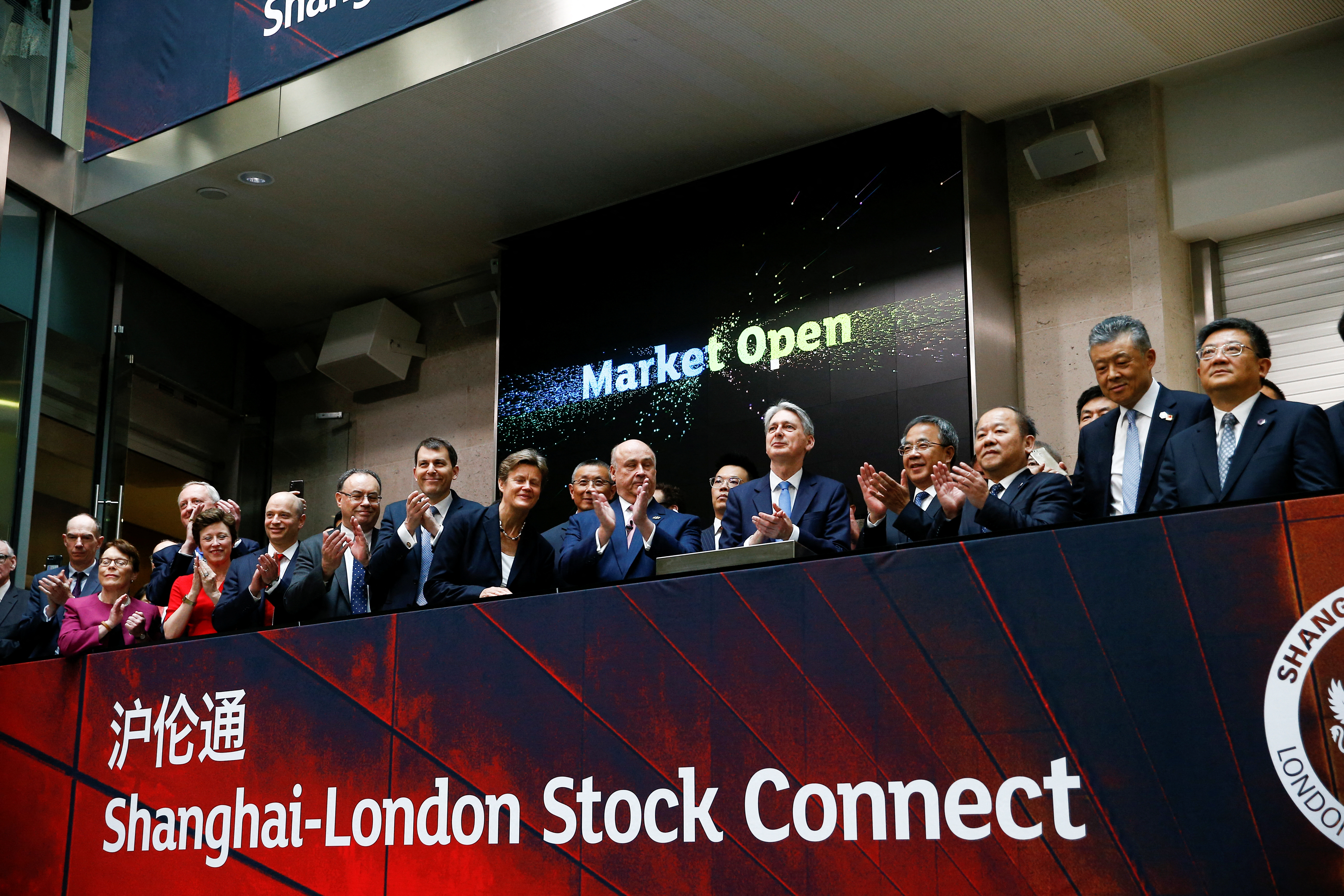 British Chancellor of the Exchequer Philip Hammond and Chinese Vice-Premier Hu Chunhua react after the opening of the markets at the London Stock Exchange in London