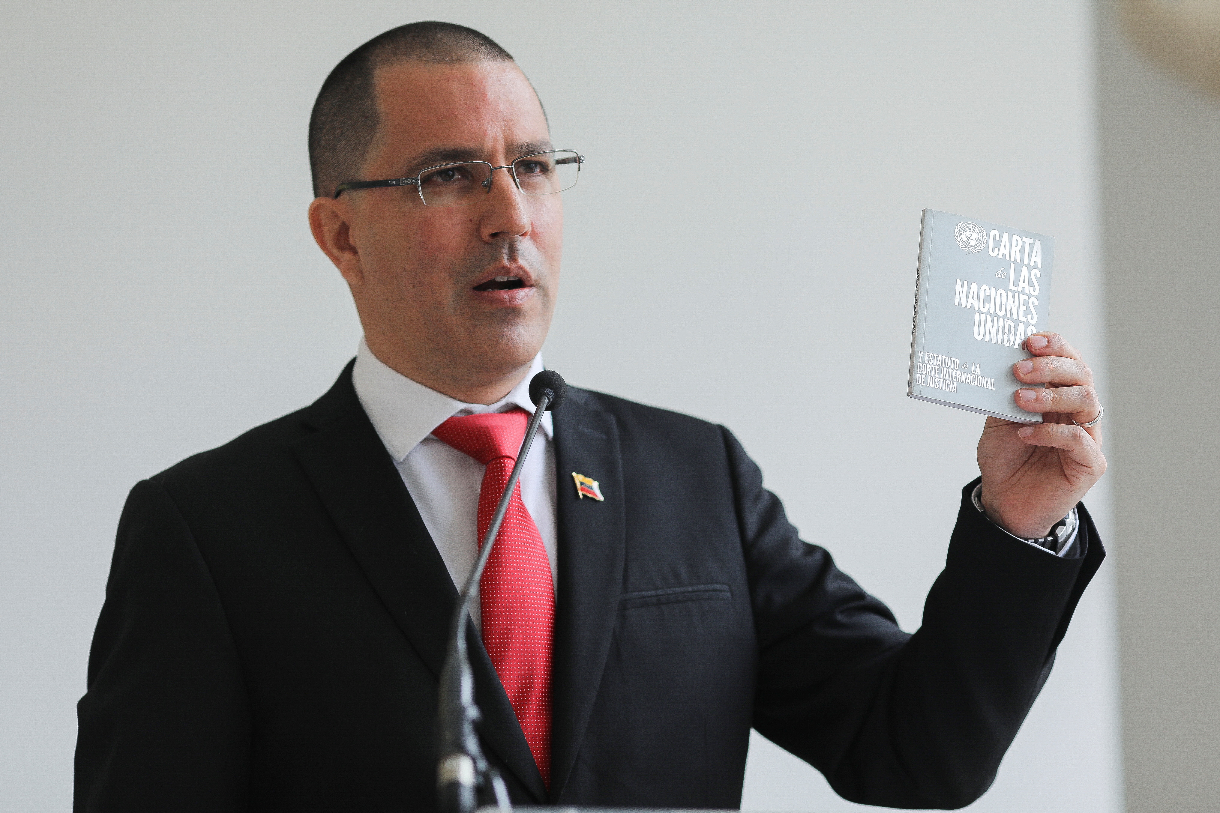 Venezuela's Foreign Minister Jorge Arreaza holds up the United Nations charter as he speaks to the media at the Foreign Ministry headquarters in Caracas, Venezuela February 24, 2021. REUTERS/Manaure Quintero