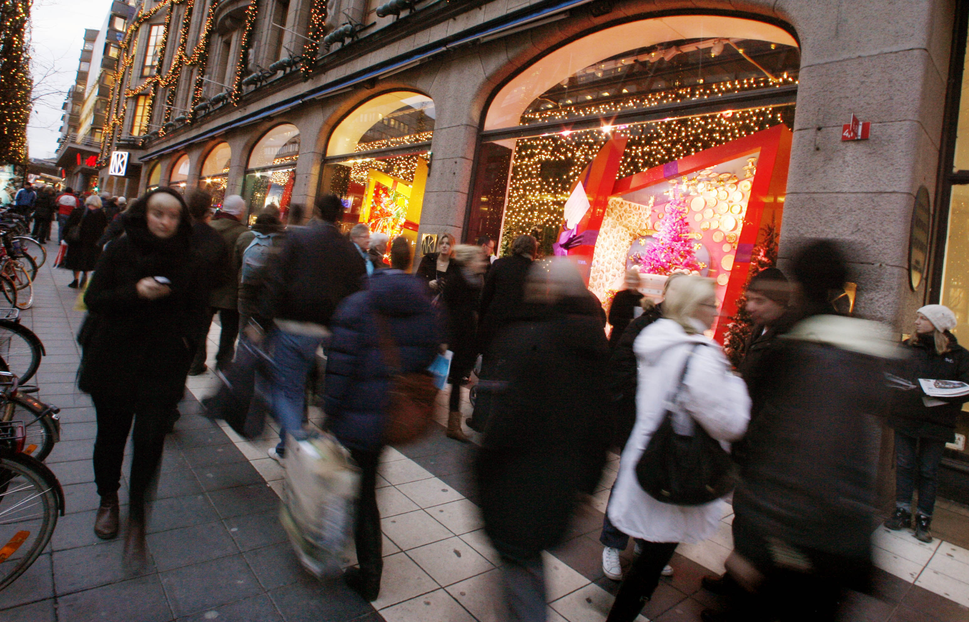 People walk past Christmas window displays at a department store in downtown Stockholm