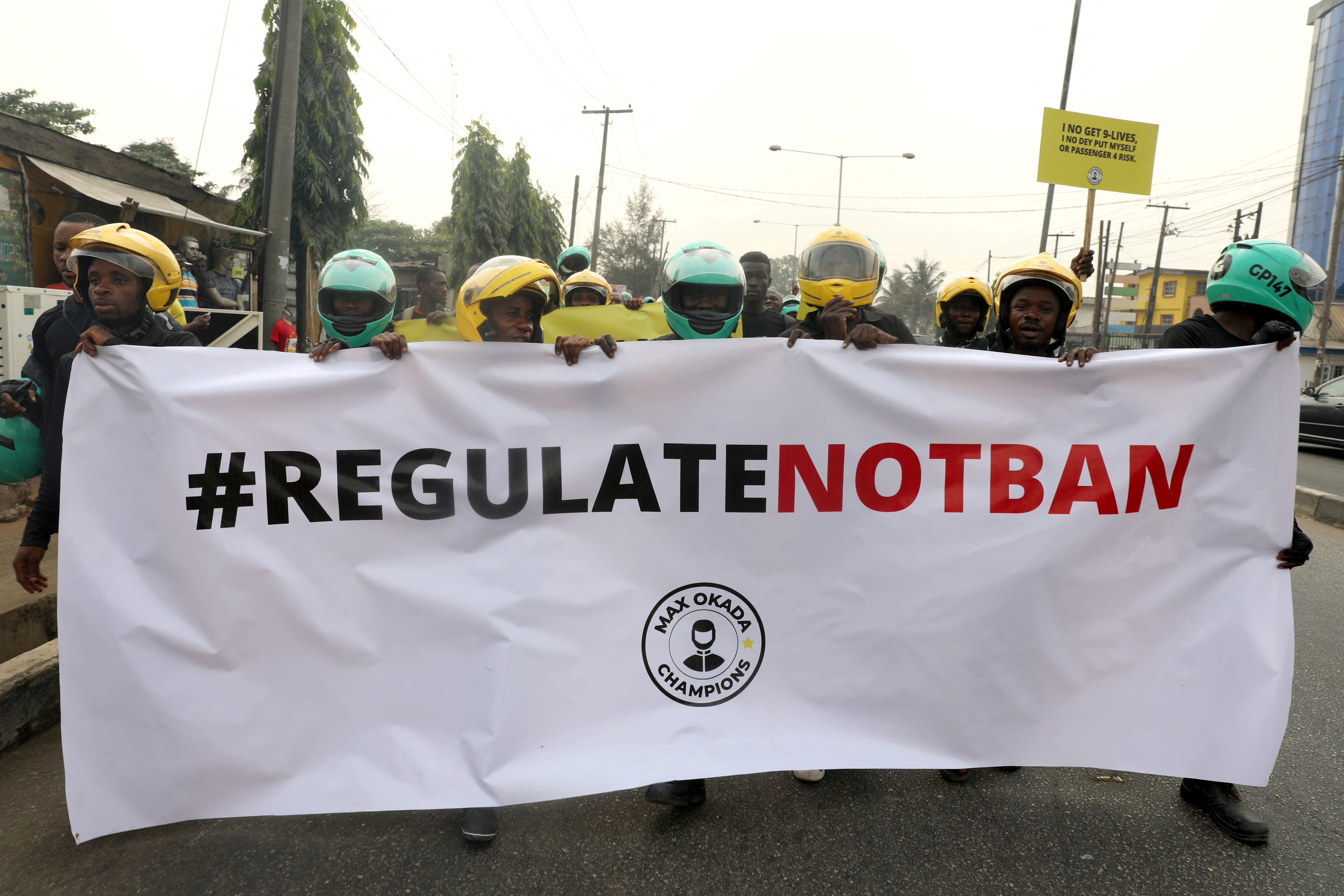Members of the Transportation Hailing Alliance of Nigeria hold a banner as they protest against the ban of commercial motorcycles in Lagos