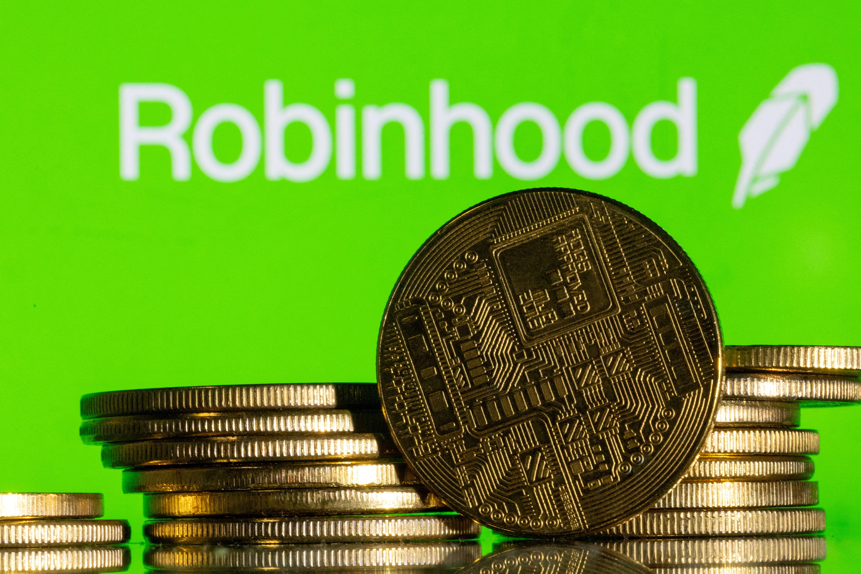 Illustration shows Robinhood logo and representations of cryptocurrency