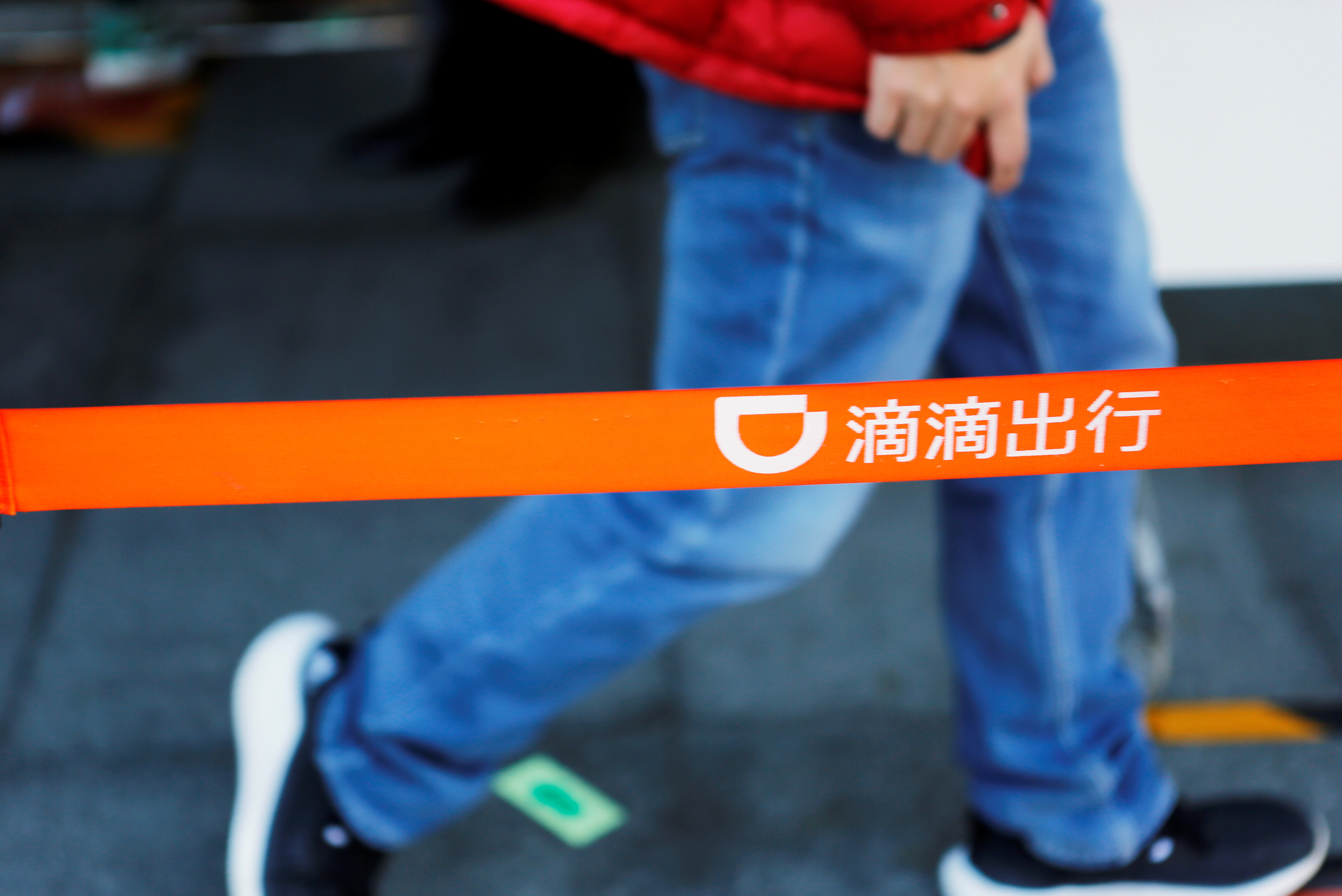 A man walks past a Didi logo at the headquarters of Didi Chuxing in Beijing, China November 20, 2020. REUTERS/Florence Lo/Files