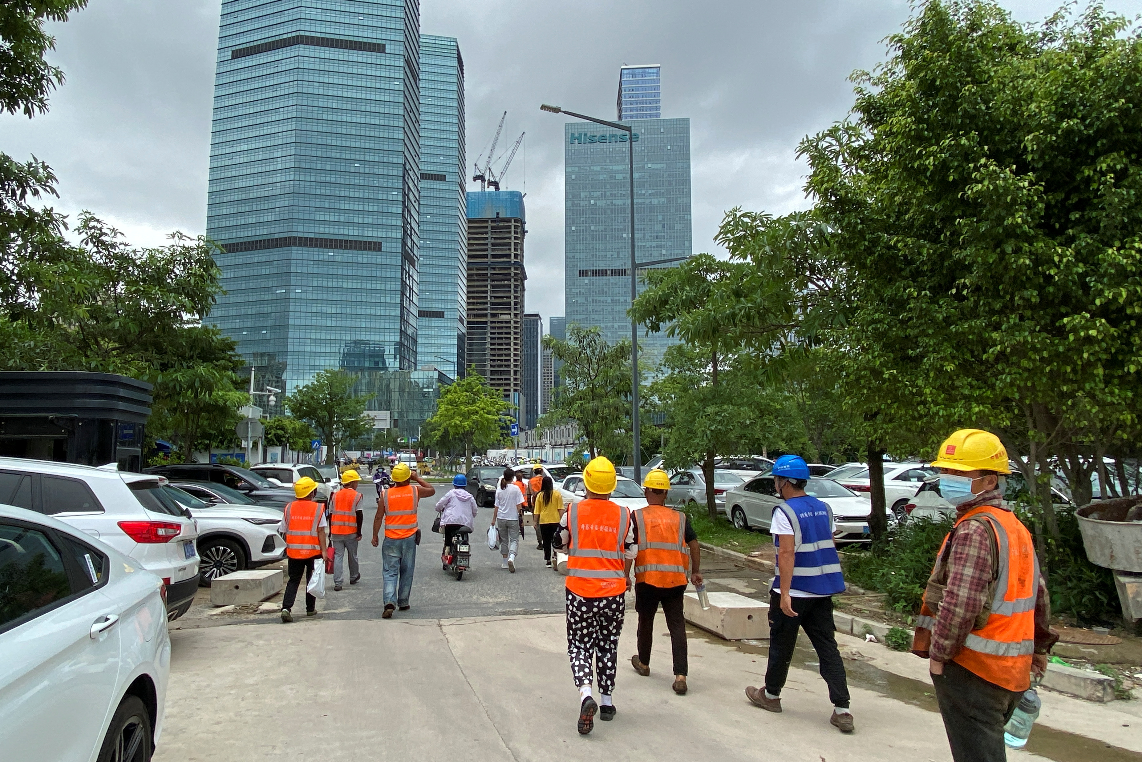 Construction workers walk past office buildings in Shenzhen's Nanshan distric