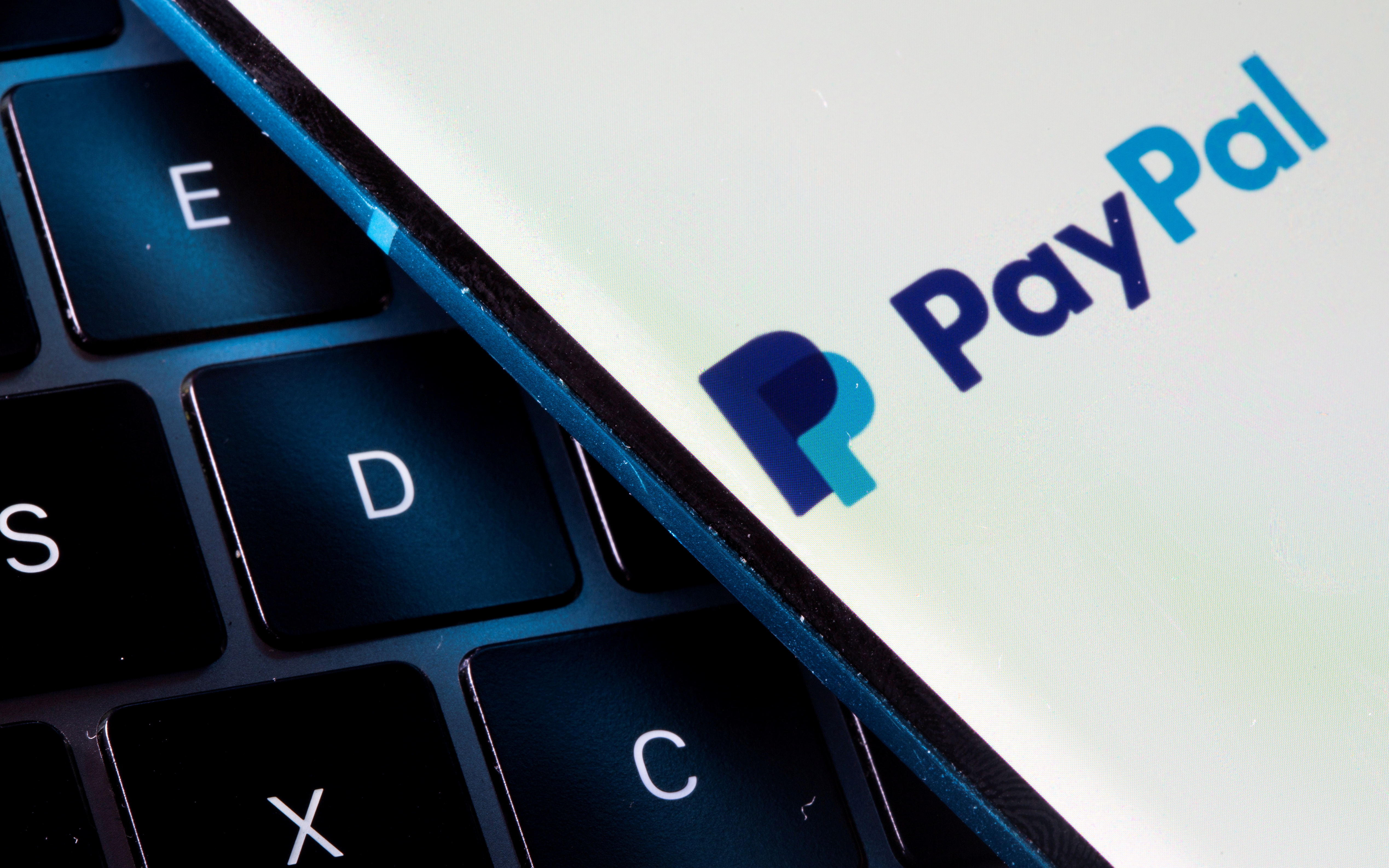 A smartphone with the PayPal logo is placed on a laptop in this illustration taken on July 14, 2021. REUTERS/Dado Ruvic/Illustration