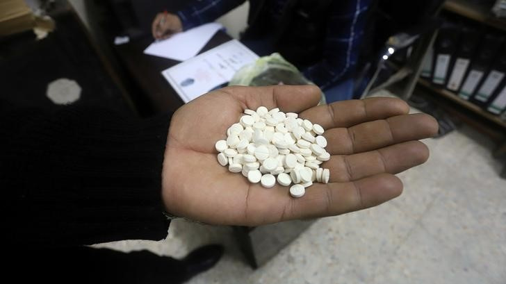 A police officer shows drug pills at a police station in Basra