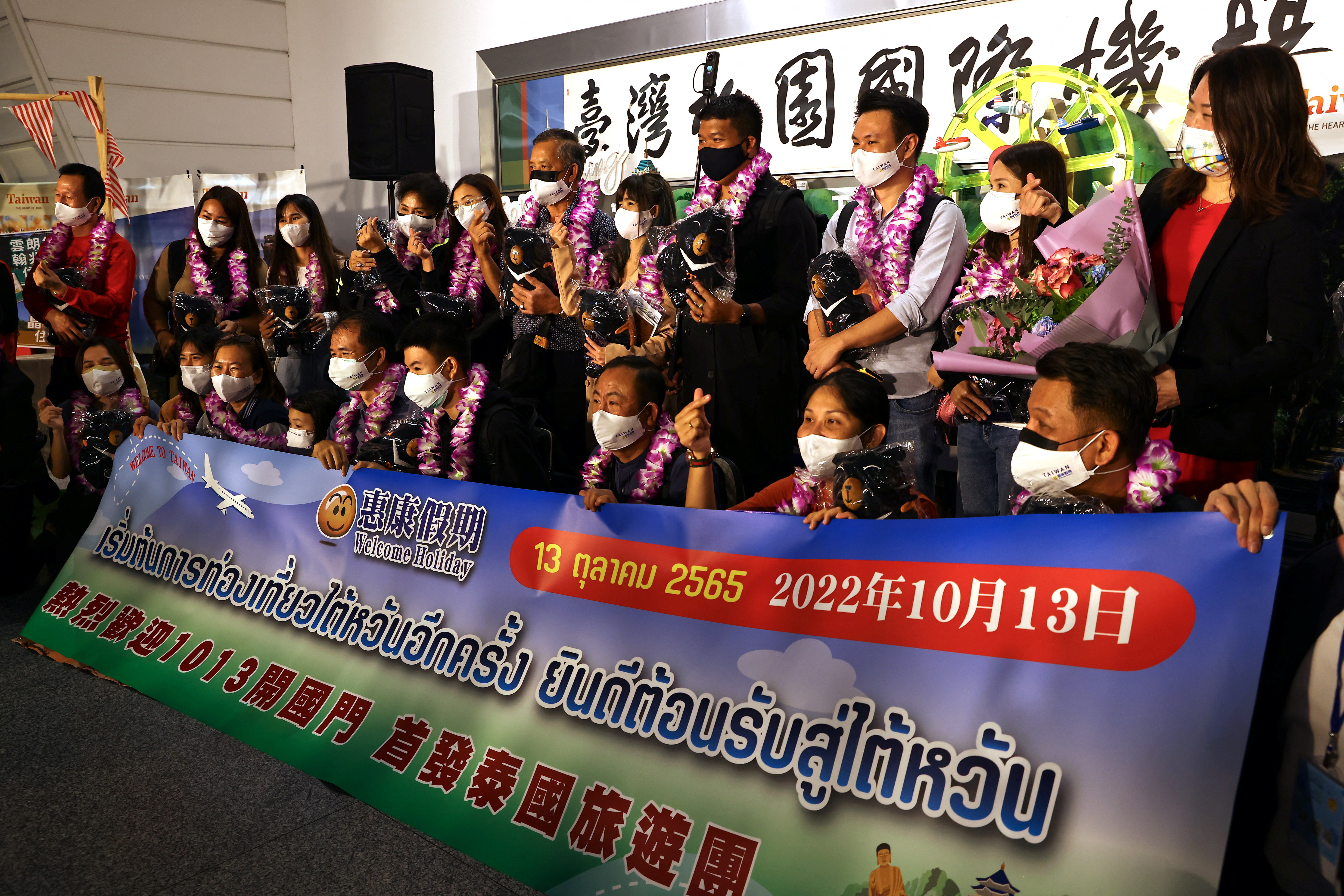 Travellers from Thailand on the first quarantine-free flight to Taiwan, amid the coronavirus disease (COVID-19) pandemic, pose for a group photo at the airport in Taoyuan