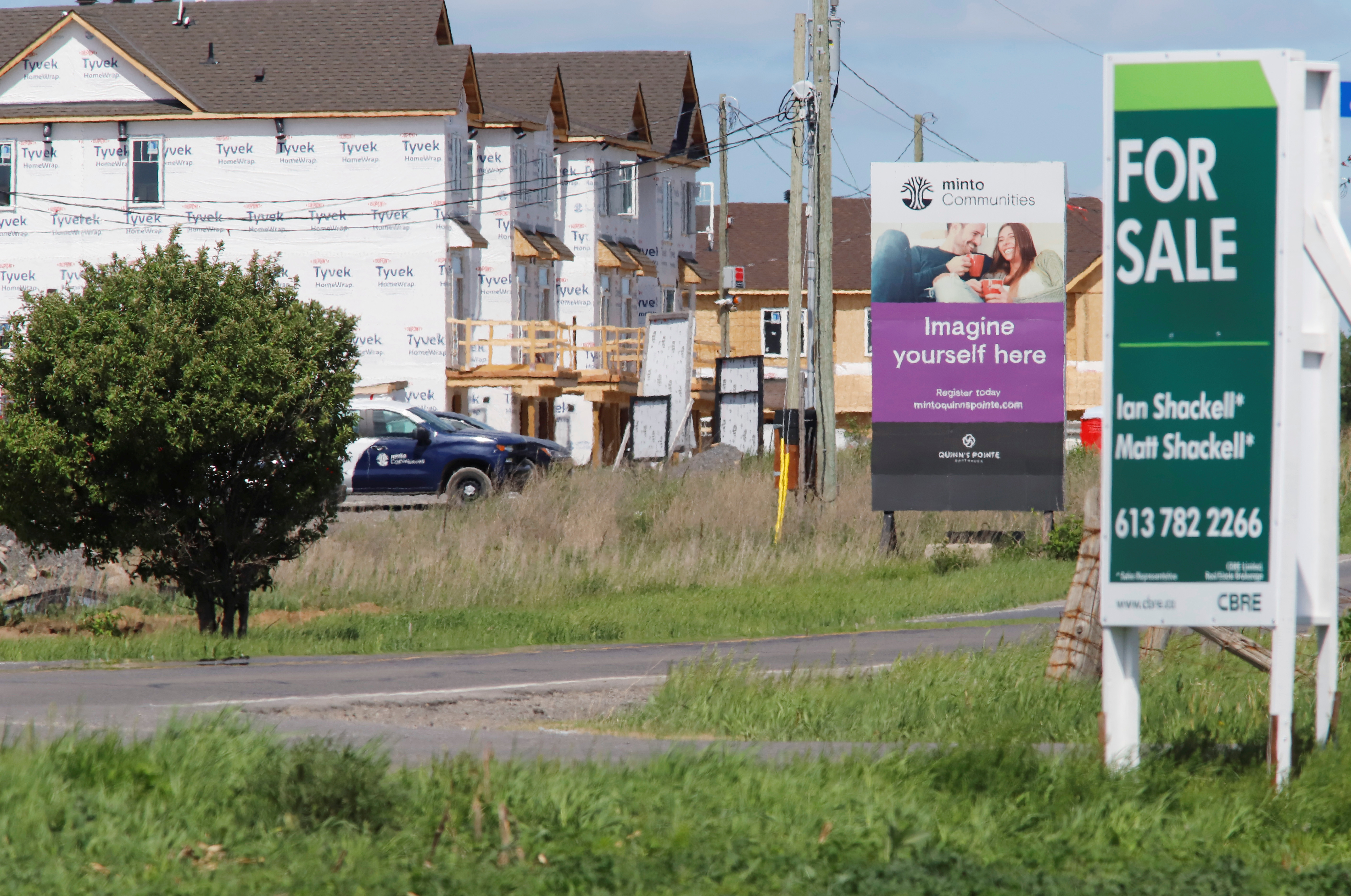 Real estate signs stand in front of new homes being constructed in Ottawa in Ottawa