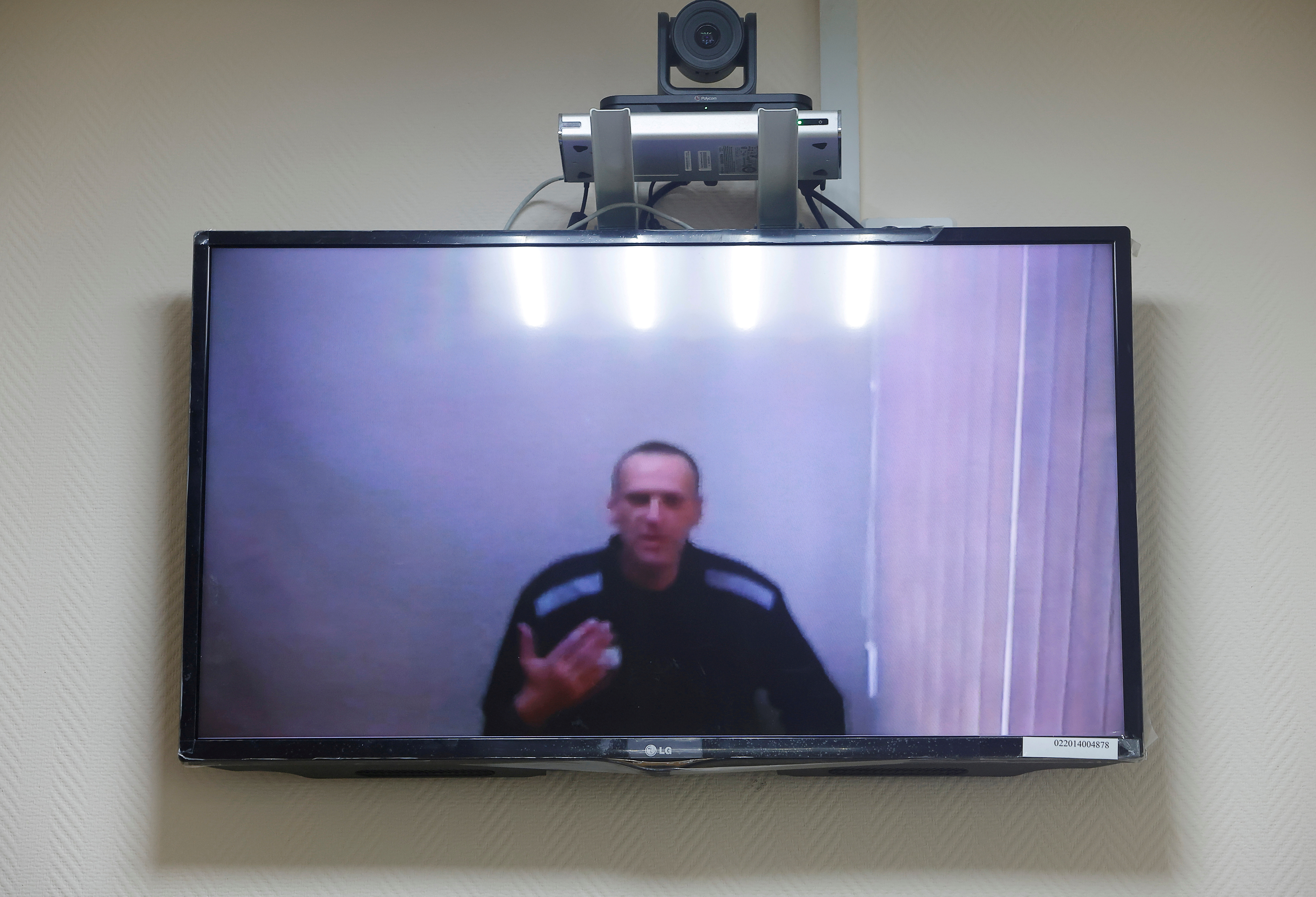 Russian opposition leader Alexei Navalny is seen on a screen via a video link during a hearing to consider his lawsuits against the penal colony over detention conditions there, at the Petushki district court in Petushki, Russia May 26, 2021. REUTERS/Maxim Shemetov