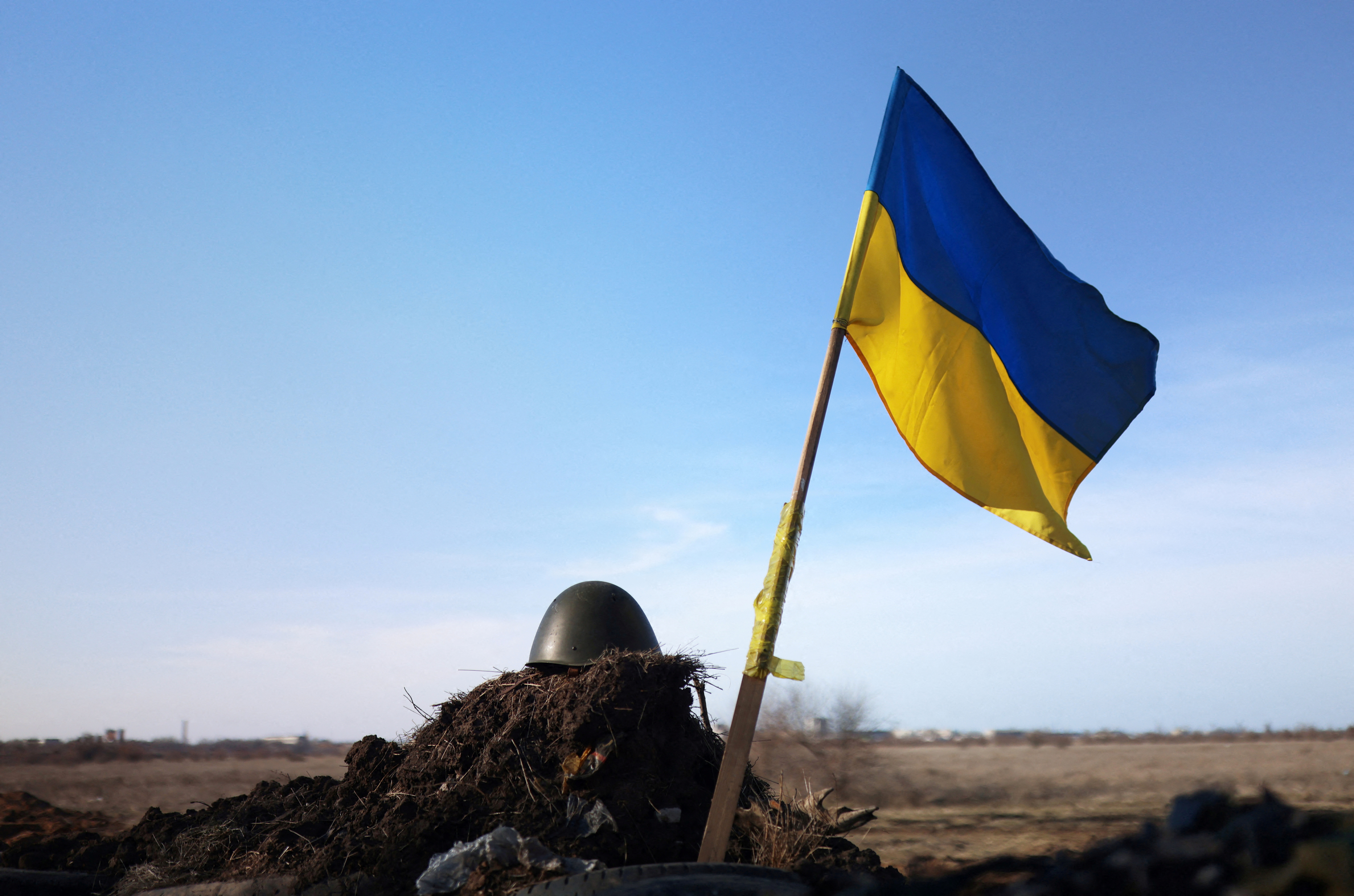 A Ukrainian flag and a helmet of a soldier are pictured at checkpoint, as Russia's invasion of Ukraine continues, in Mykolaiv
