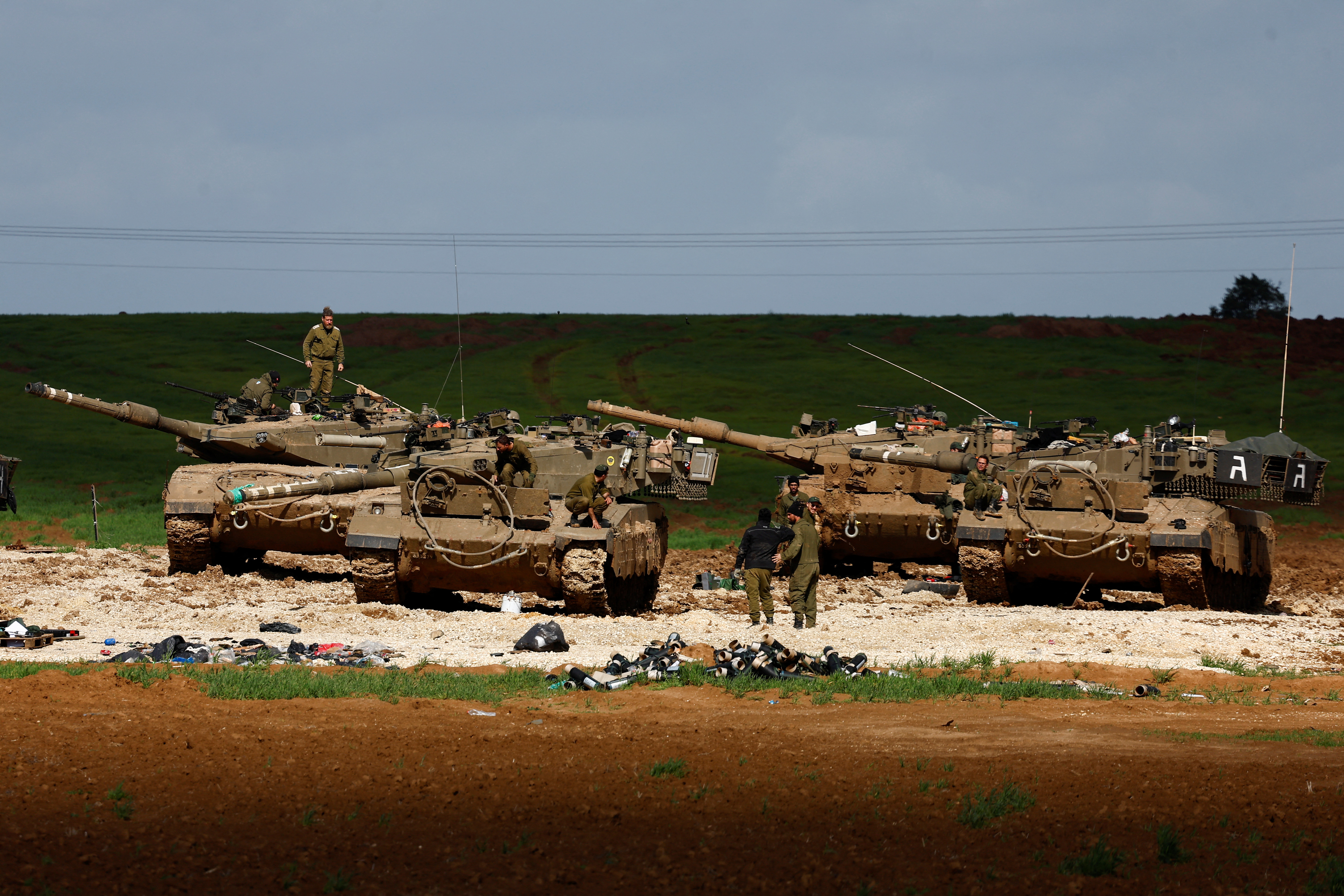 Israeli soldiers work by their tanks near Israel-Gaza border