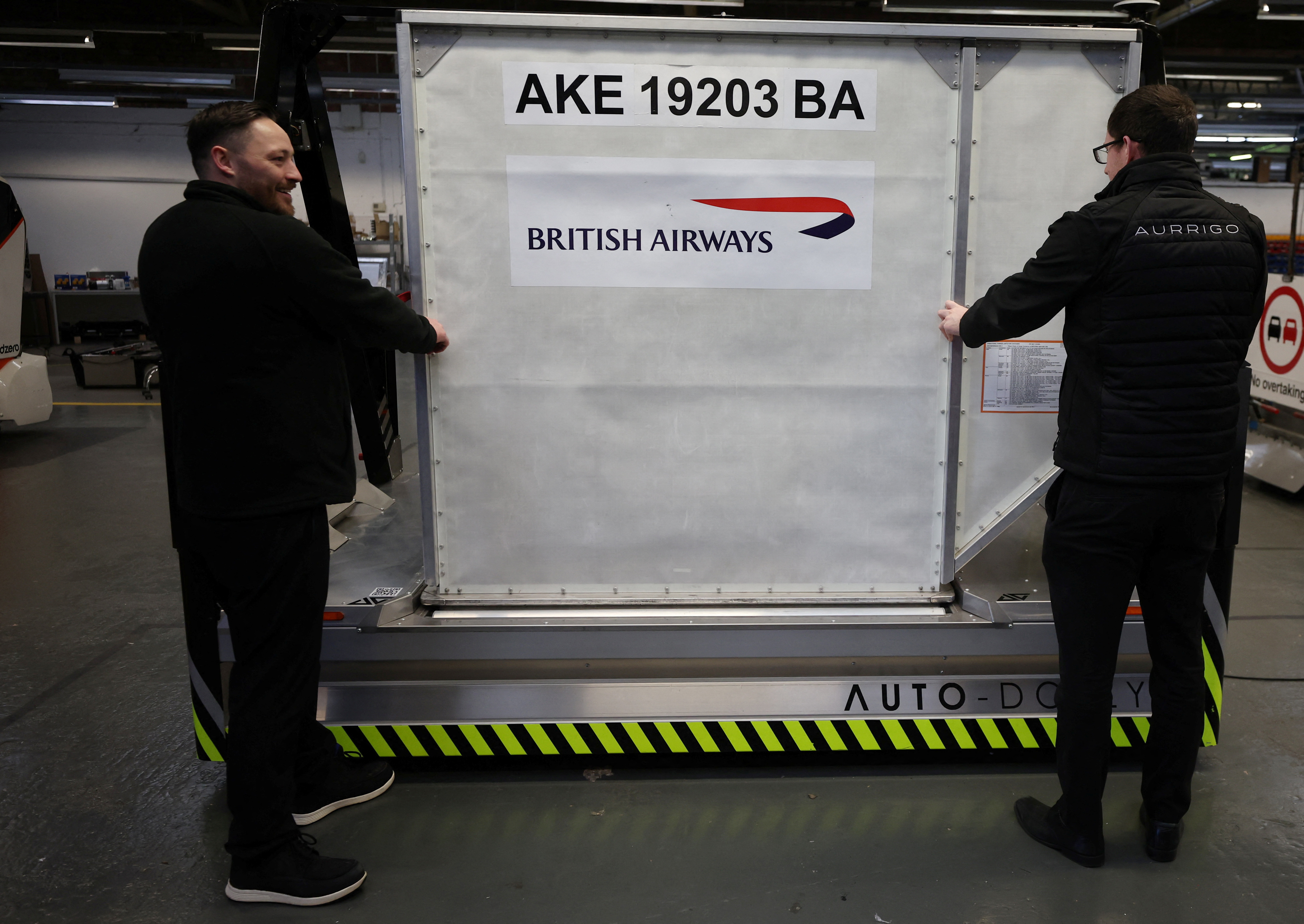 Workers adjust a baggage holder on one of the company’s autonomous ‘Auto-Dolly’ baggage transporter at the Aurrigo factory in Coventry