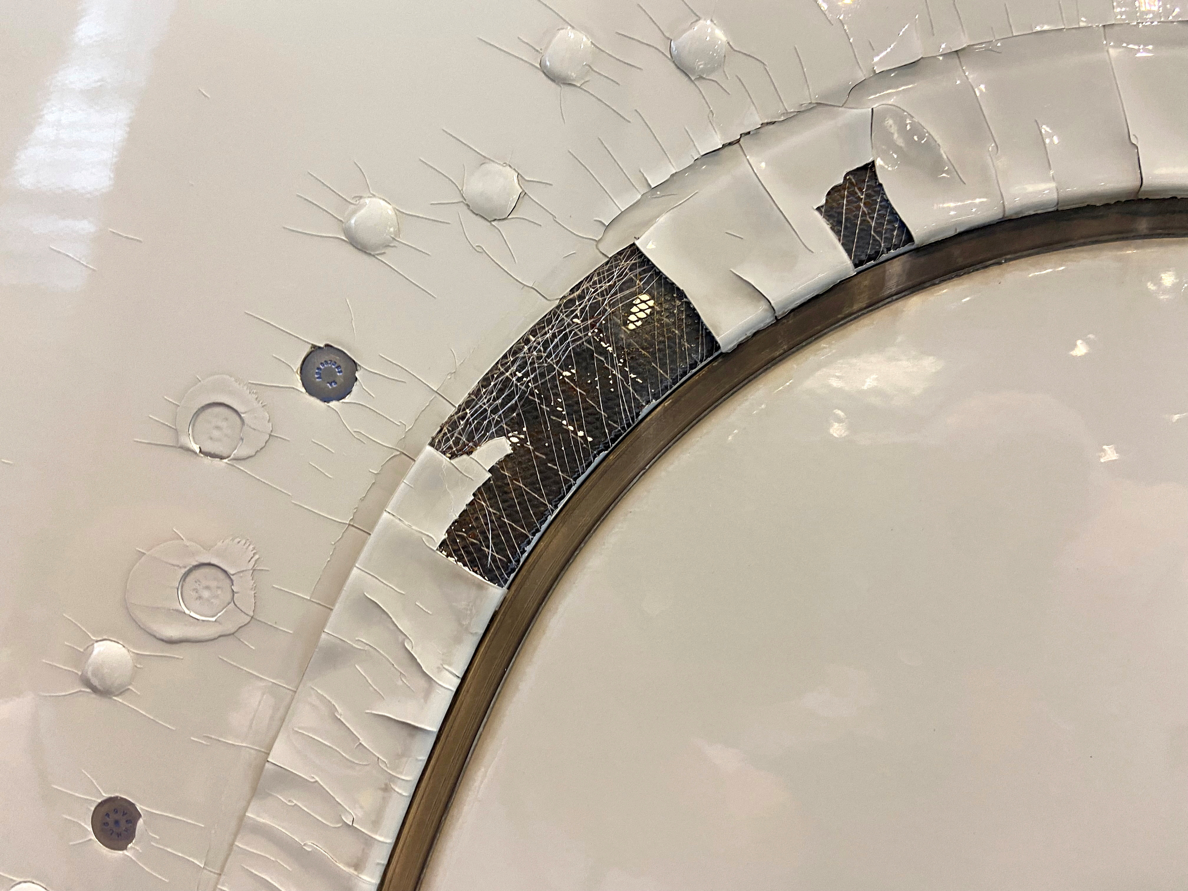 An undated image shows what appears to be paint peeling, cracking and exposed expanded copper foil (ECF) on the window of a Qatar Airways A350 aircraft