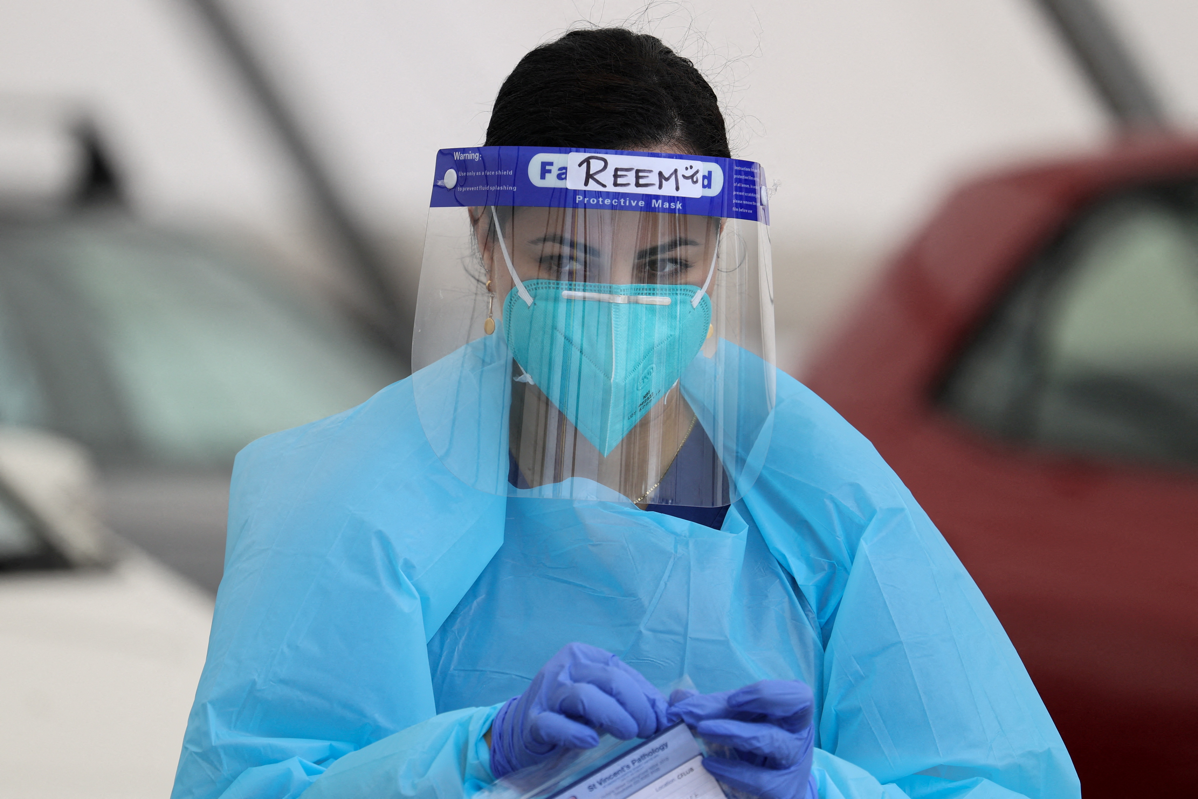 A medical worker is seen between administering tests at a drive-through COVID-19 testing centre in Sydney