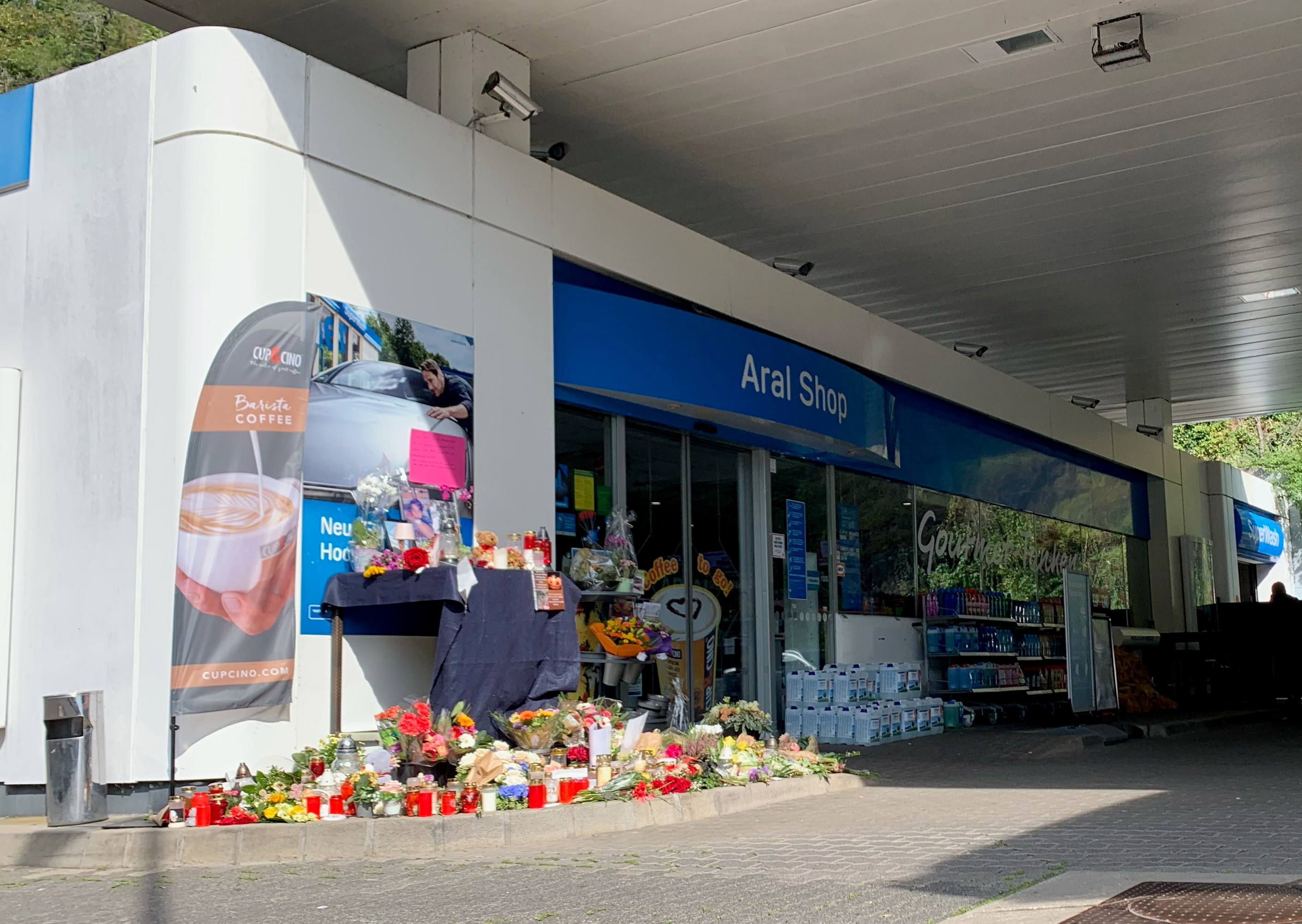 Flowers are placed in front of a gas station in Idar-Oberstein, Germany, September 21, 2021, after a 20-year-old gas station attendant who asked a customer to wear a face mask was shot dead last Saturday, September 18, 2021. REUTERS/Annkathrin Weiss
