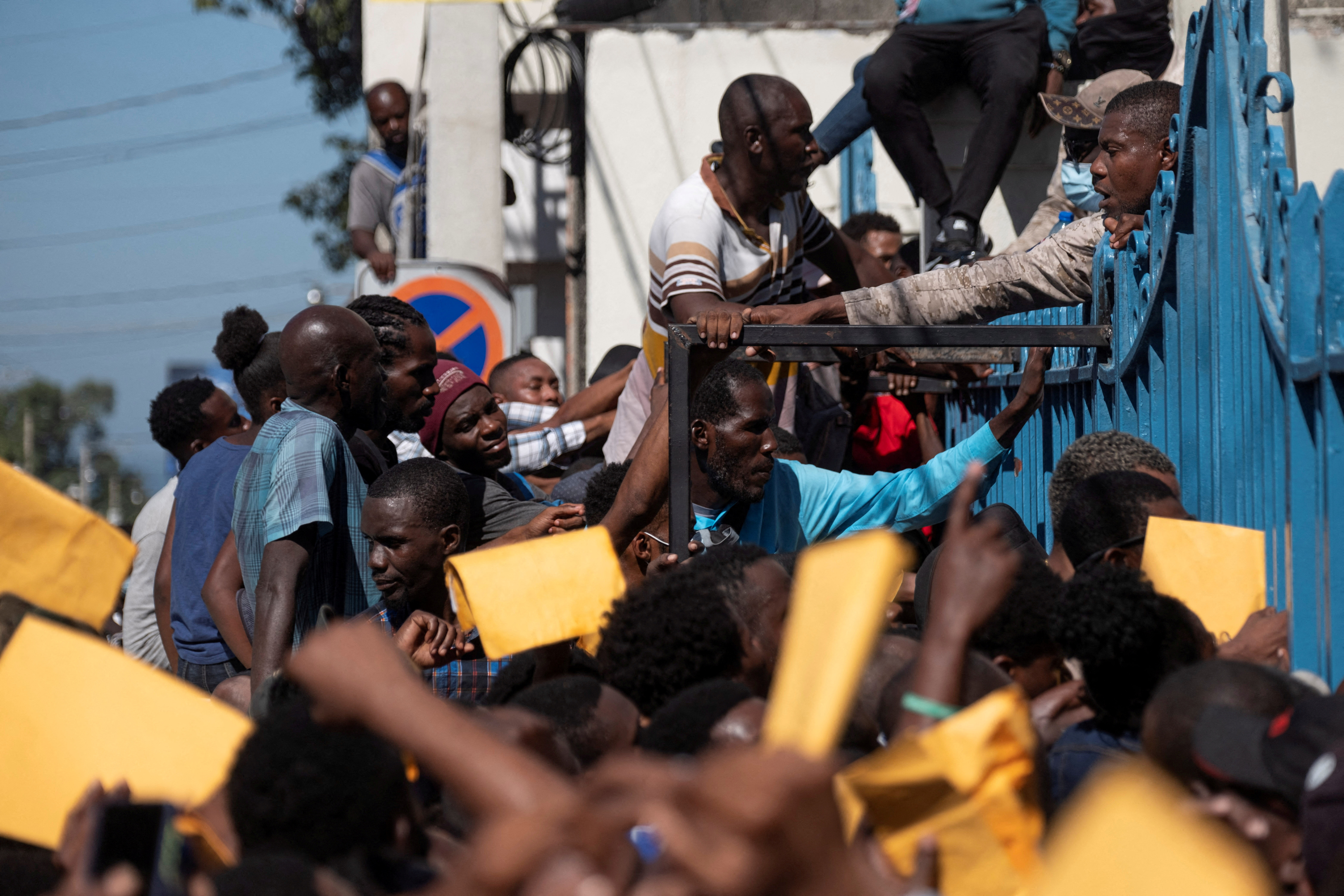 People gather outside an immigration office to apply for a passport in Port-au-Prince