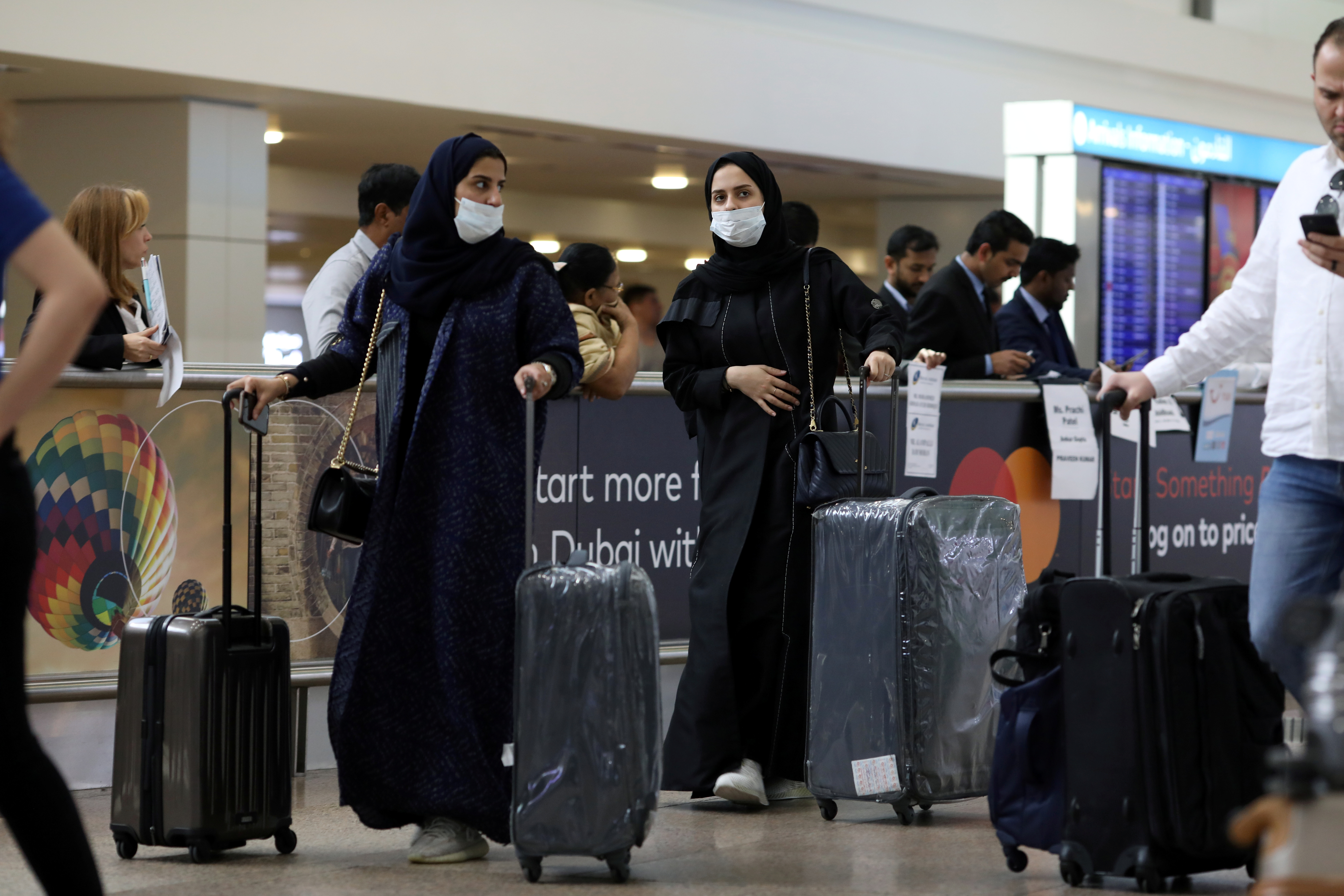 Travellers wear masks as they arrive at the Dubai International Airport, after the UAE's Ministry of Health and Community Prevention confirmed the country's first case of coronavirus, in Dubai