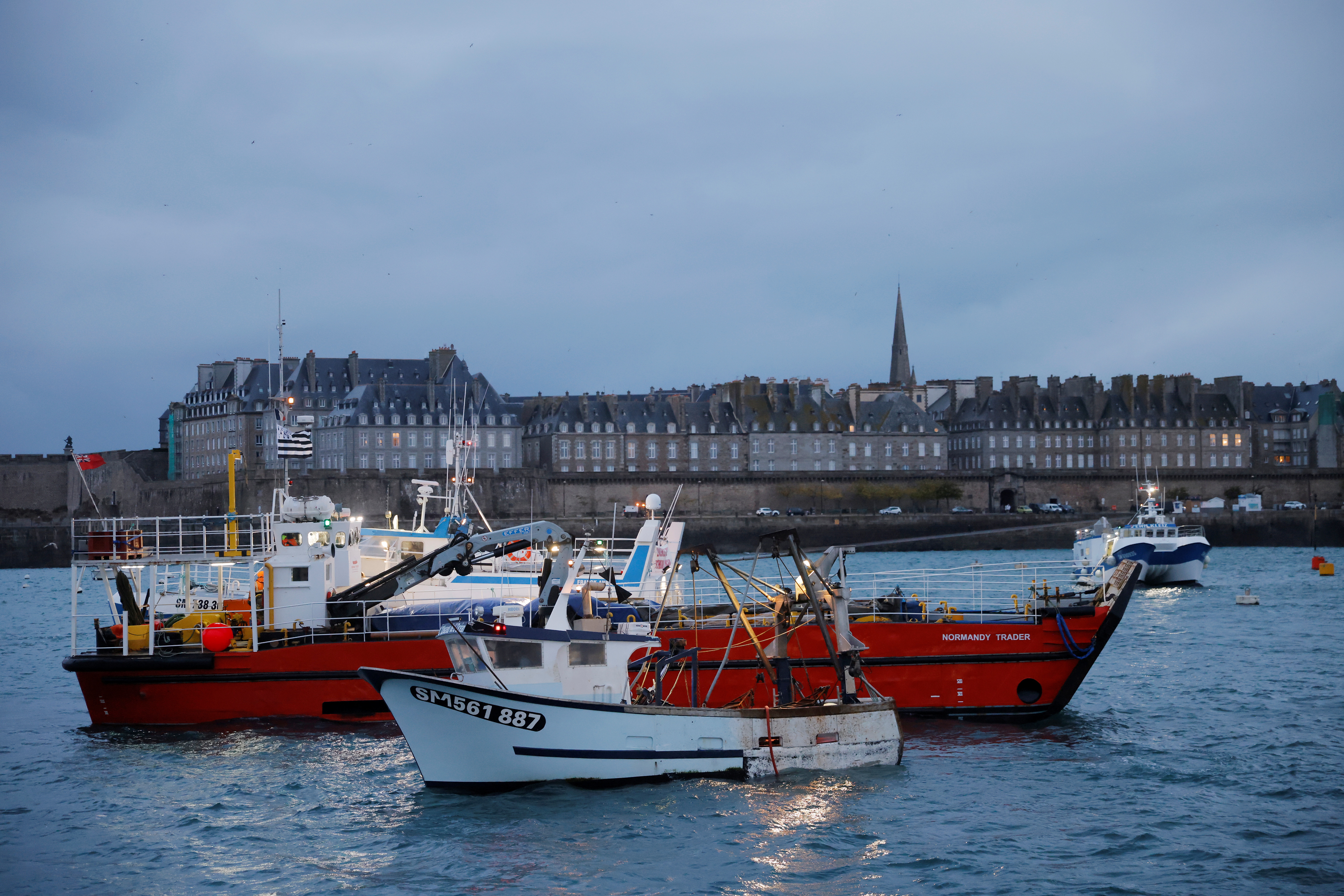 French fishermen block the 'Normandy Trader' boat at the entrance of the port of Saint-Malo as they started a day of protests to mark their anger over the issue of post-Brexit fishing licenses, in Saint-Malo, France, November 26, 2021. REUTERS/Stephane Mahe