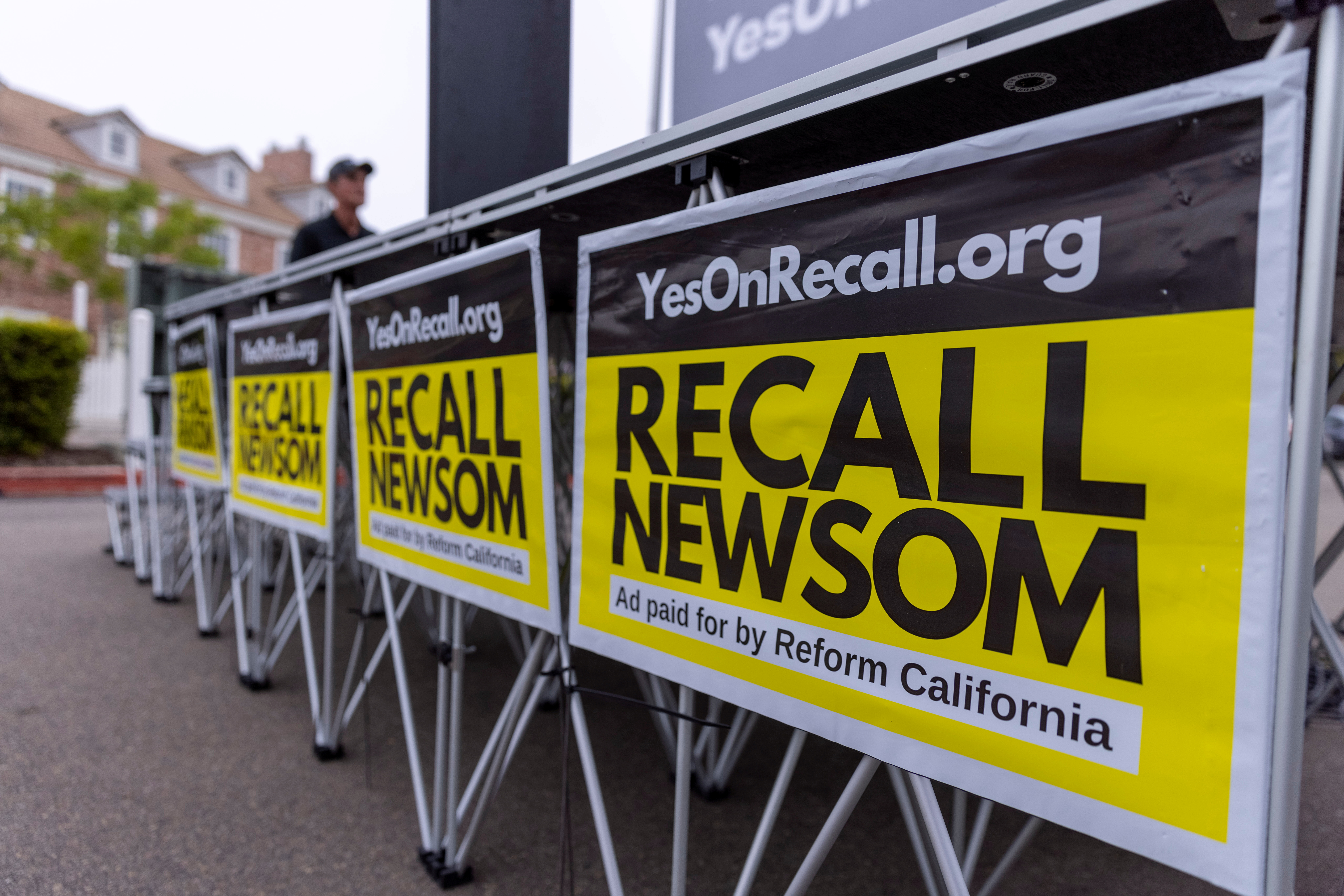 Signs are shown at a rally for the recall campaign of California governor Gavin Newsom in Carlsbad