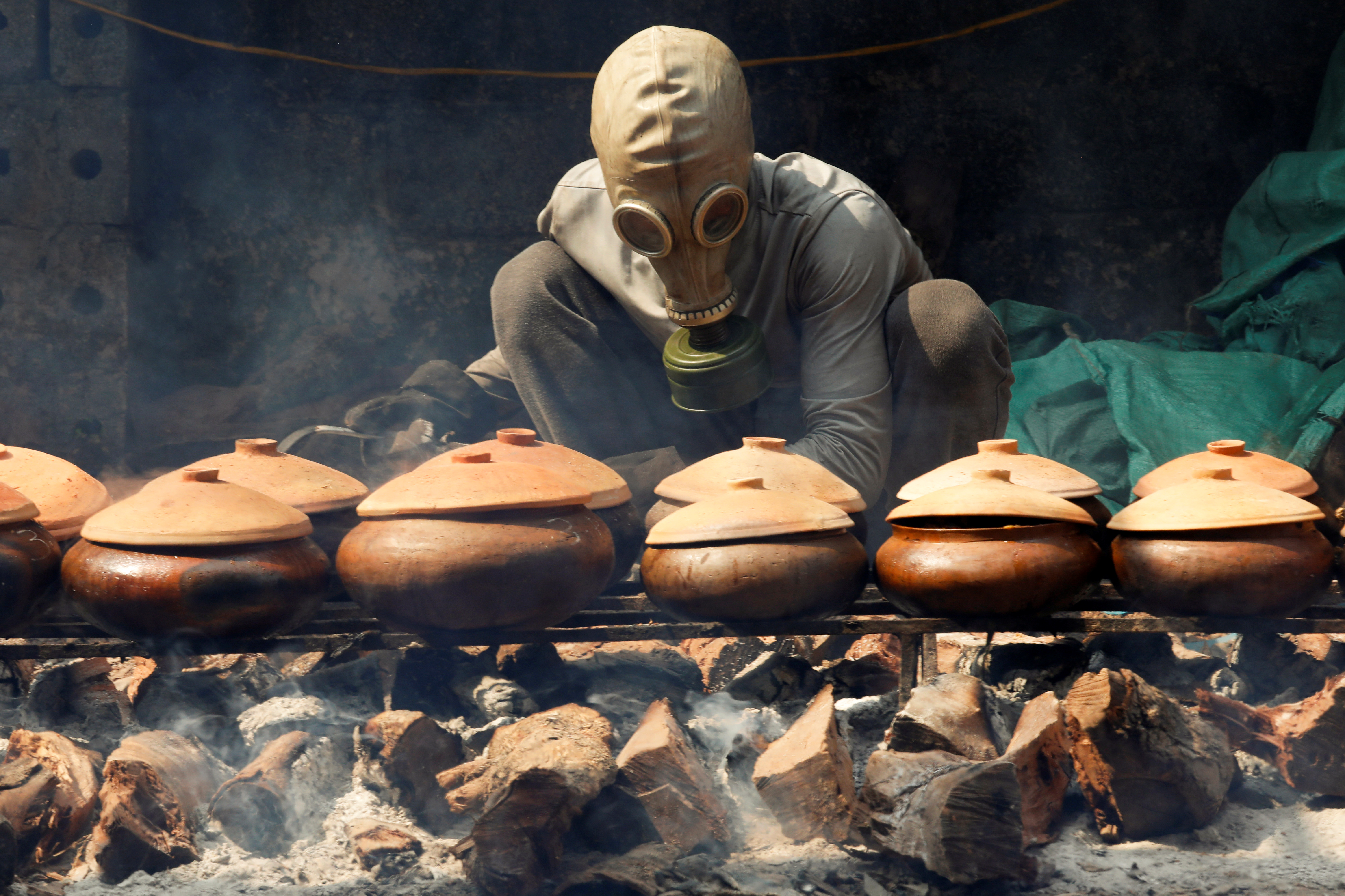 Gas mask on to braise black carp for the Lunar New Year Reuters