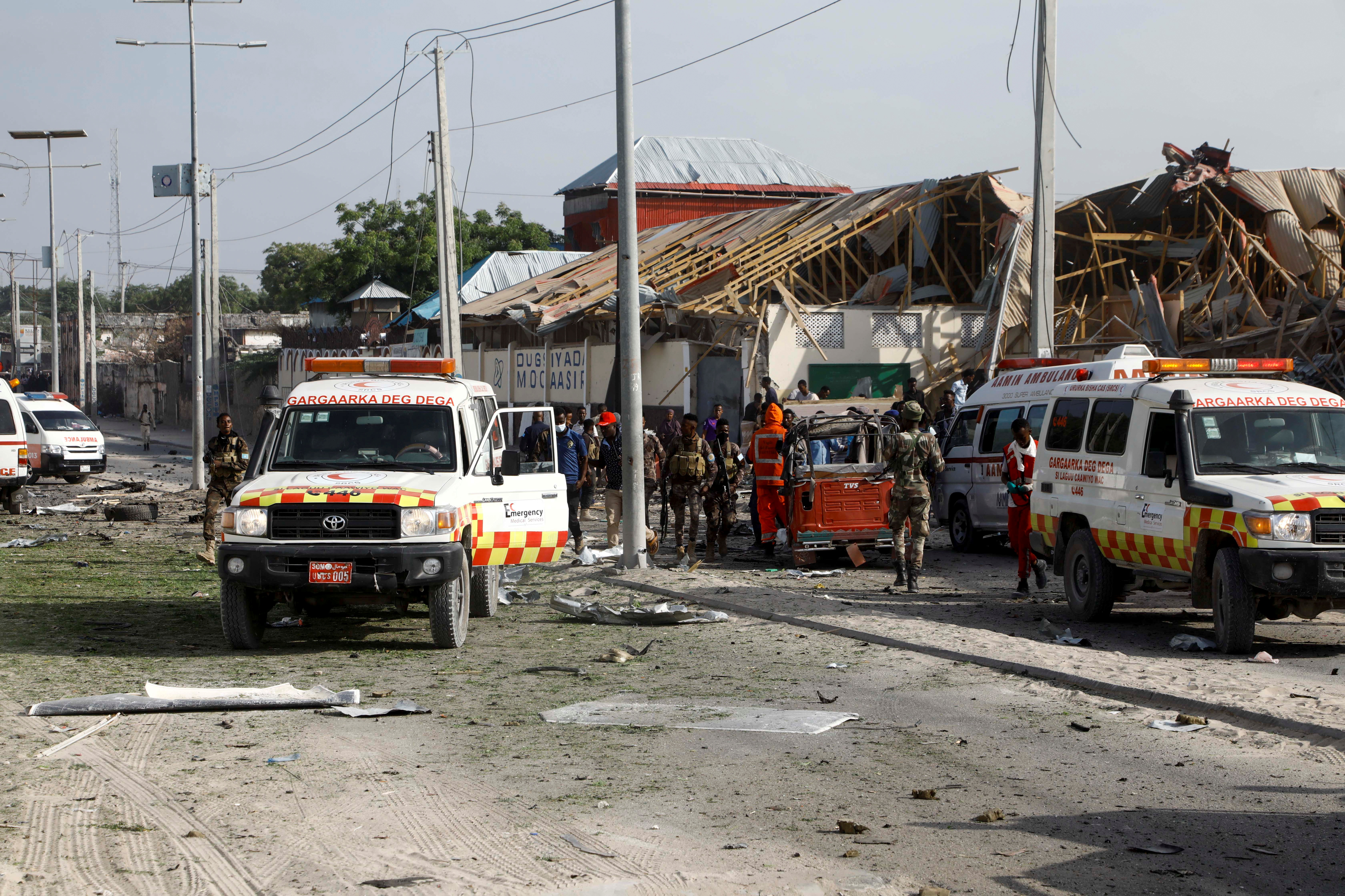 Somali police and paramedics are seen at the scene after a car exploded in a suicide attack near Mucassar primary and secondary school in Hodan district of Mogadishu