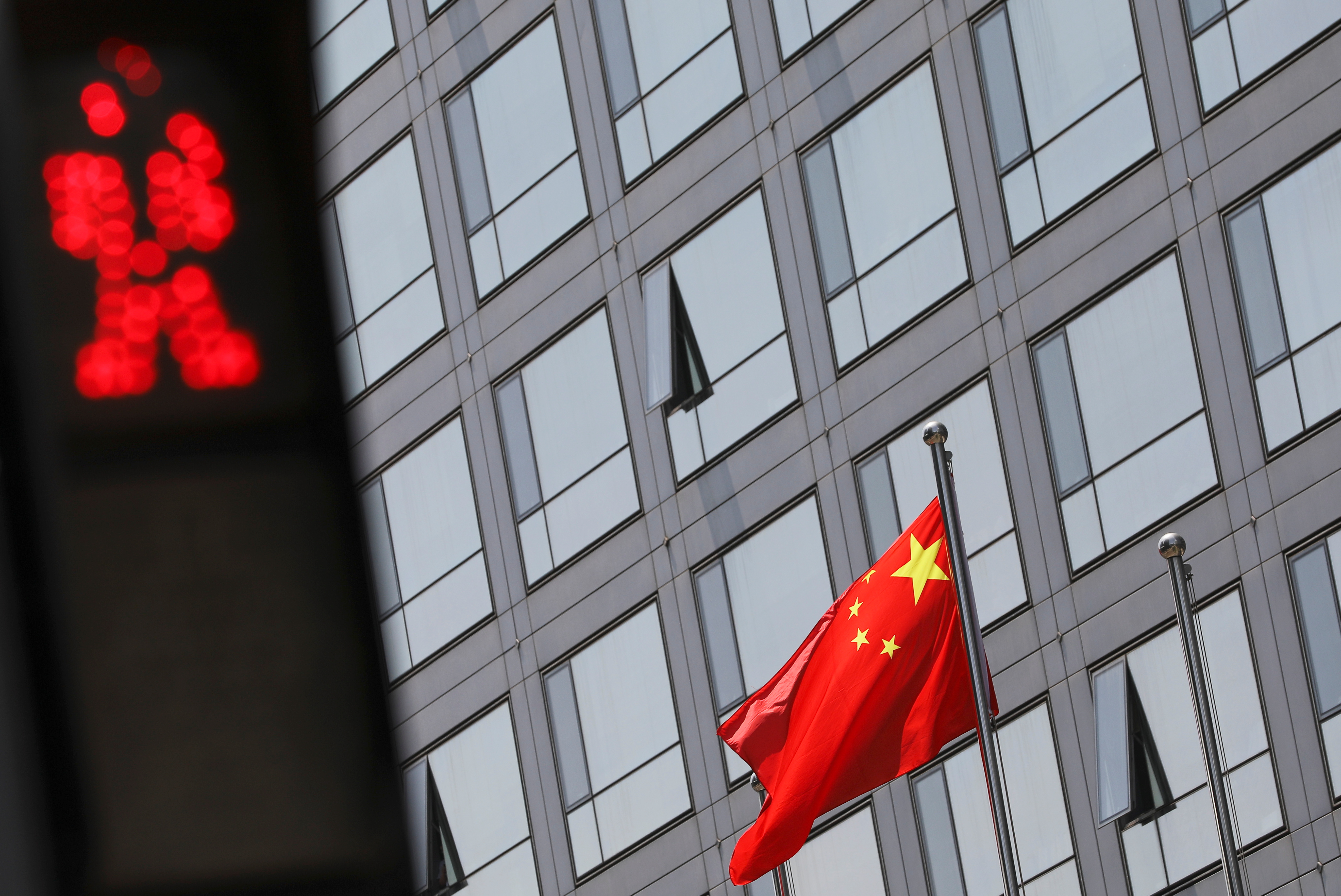 A Chinese national flag flutters outside the China Securities Regulatory Commission (CSRC) building on the Financial Street in Beijing, China July 9, 2021. REUTERS/Tingshu Wang