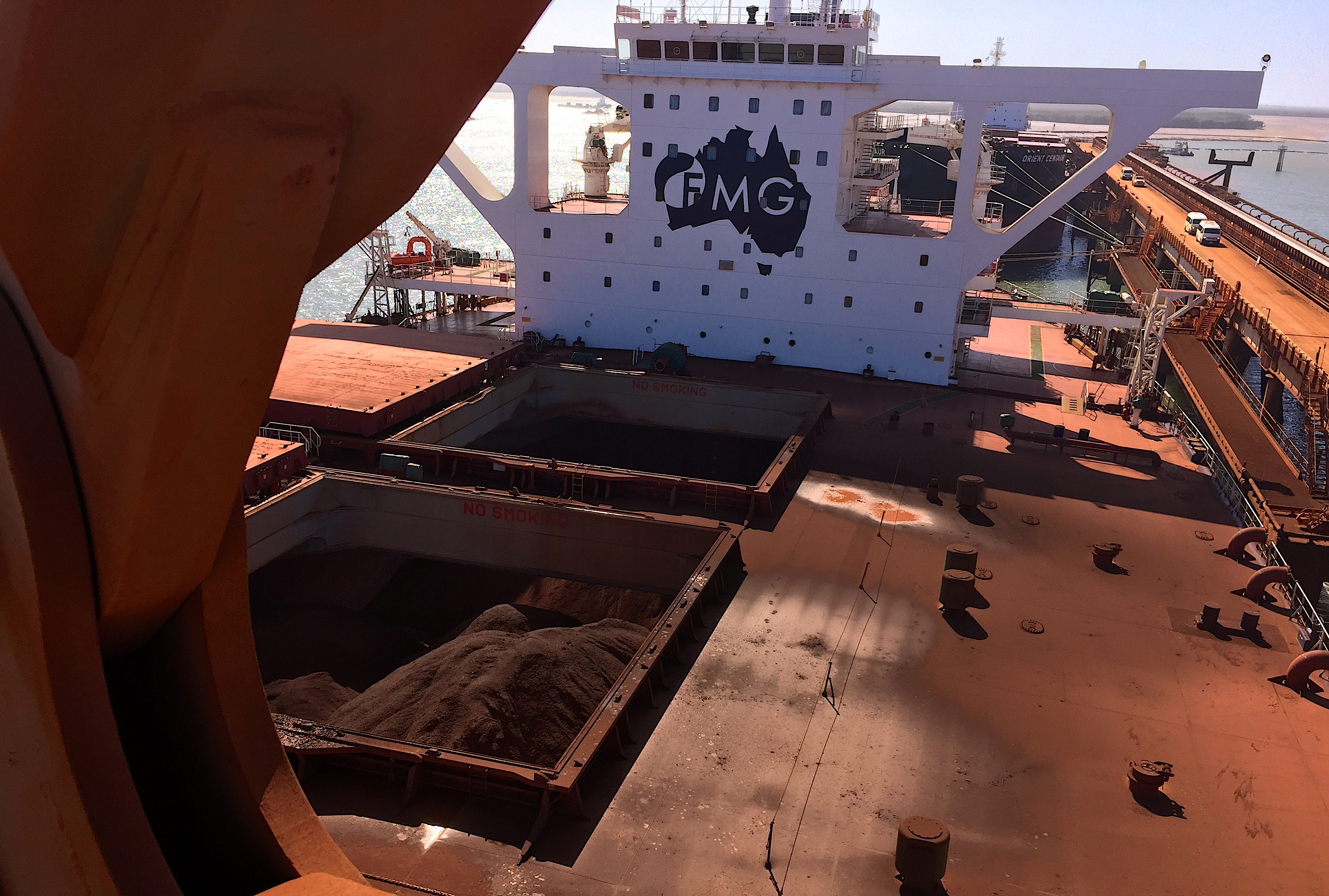 The logo of Australia's Fortescue Metals Group can be seen on a bulk carrier as it is loaded with iron ore at the coastal town of Port Hedland in Western Australia