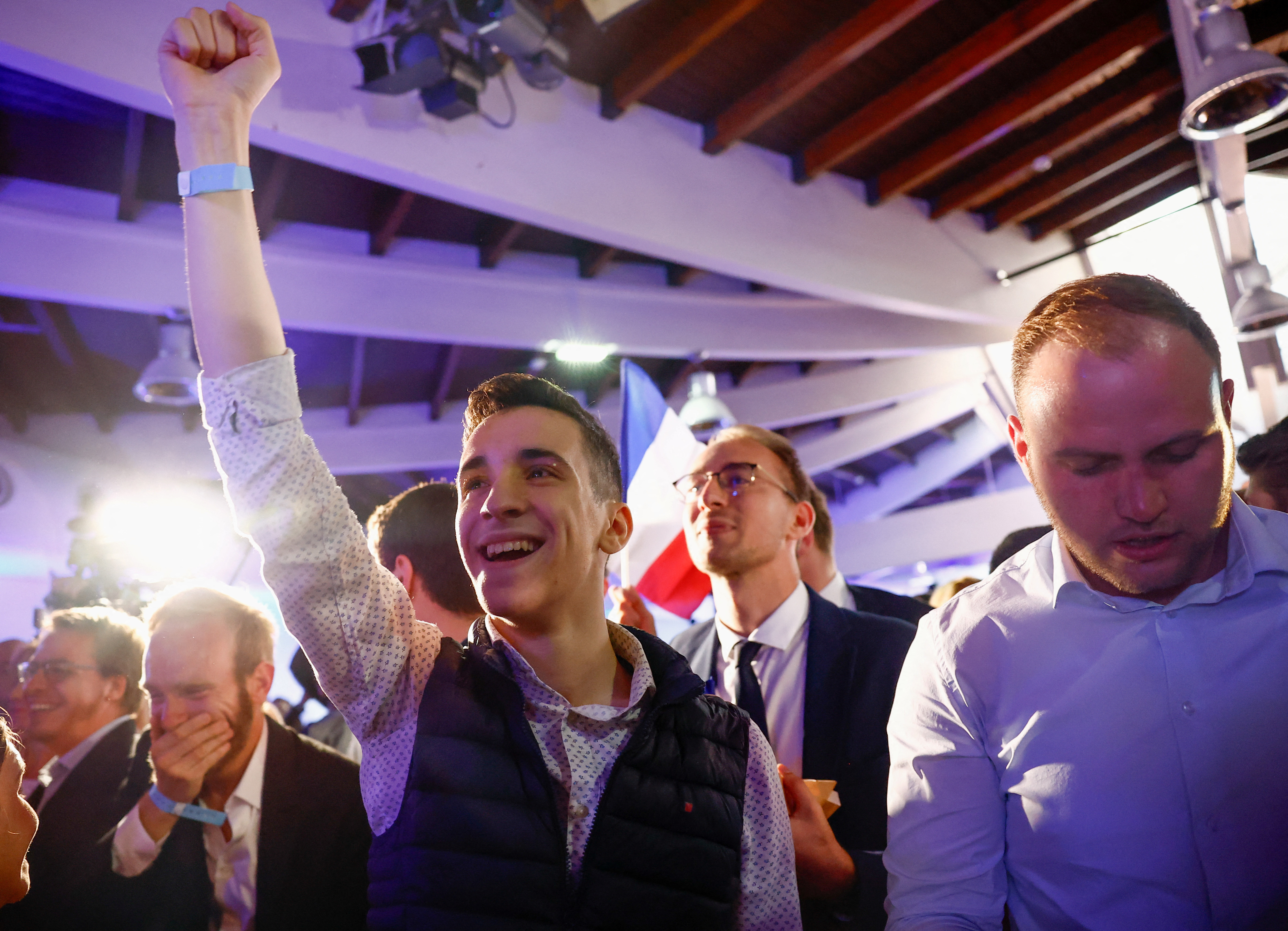 Far-right National Rally (Rassemblement National - RN) party members react after the polls closed during the European Parliament elections, in Paris