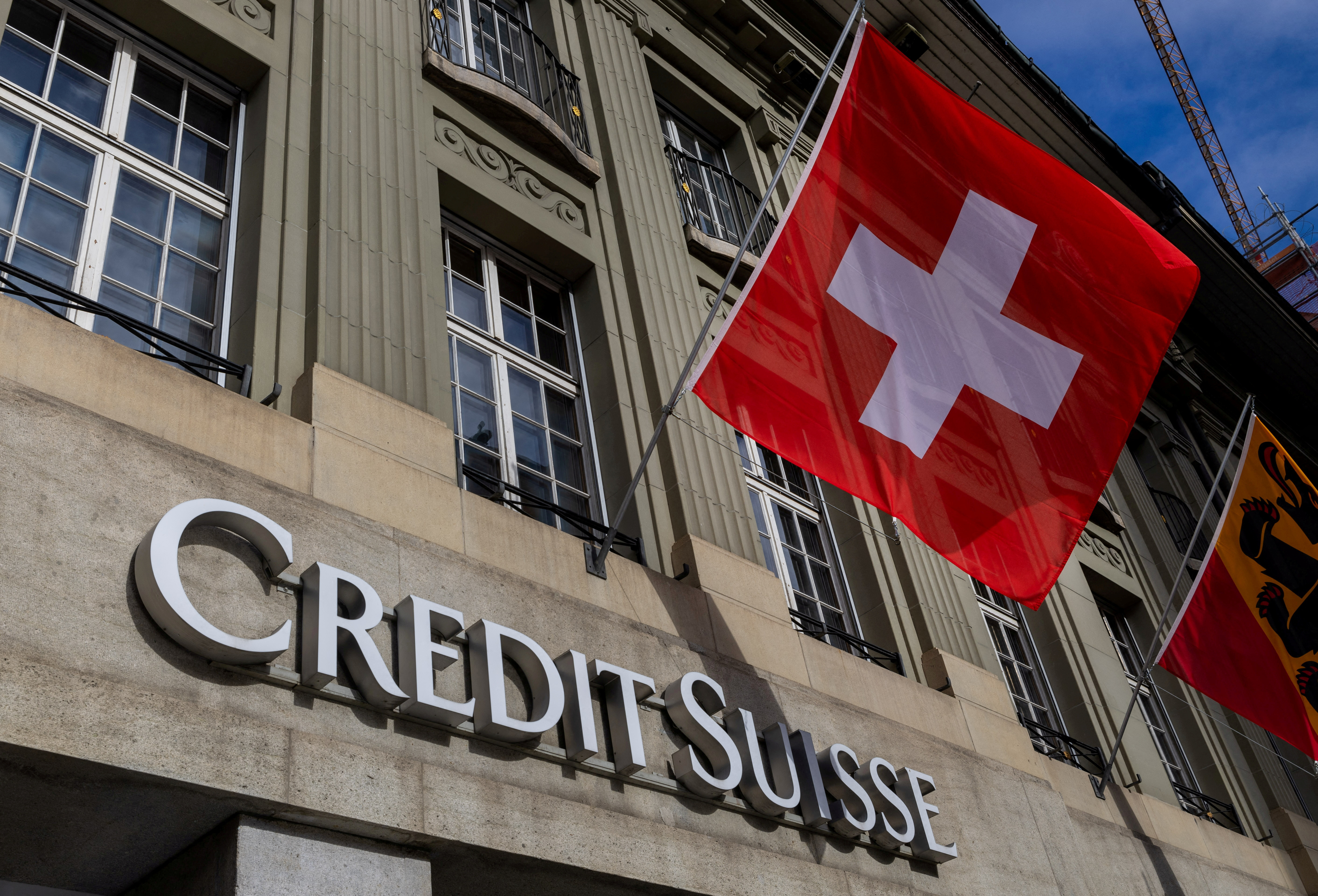 A Swiss flag is pictured above a logo of Swiss bank Credit Suisse in Bern