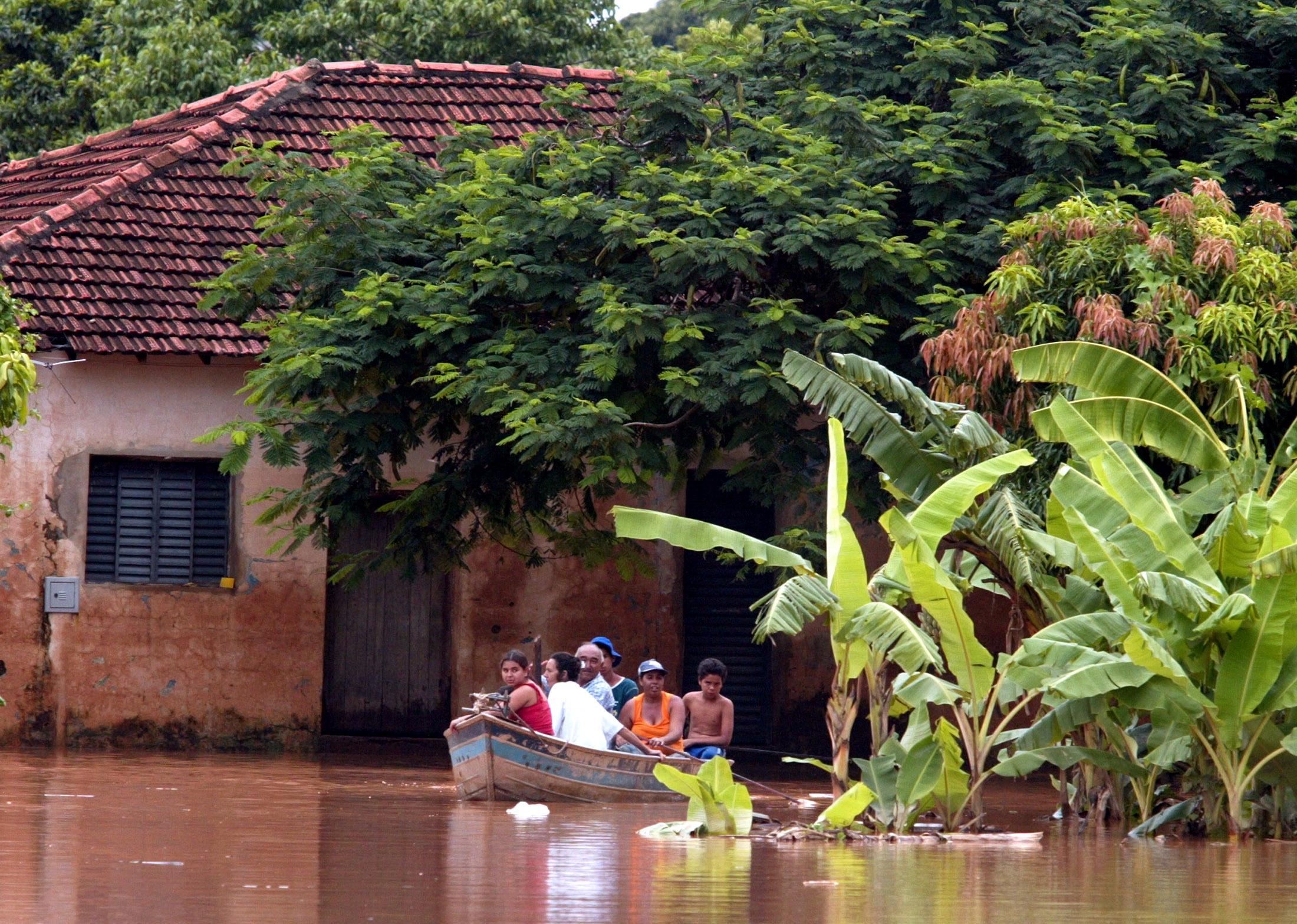 Cư dân ở thành phố Unai, miền đông nam Brazil, thuộc bang Minas Gerais, cách Brasilia khoảng 170 km, đi thuyền dọc khu phố ngập lụt, ngày 4 tháng 3 năm 2005. REUTERS / Jamil Bittar