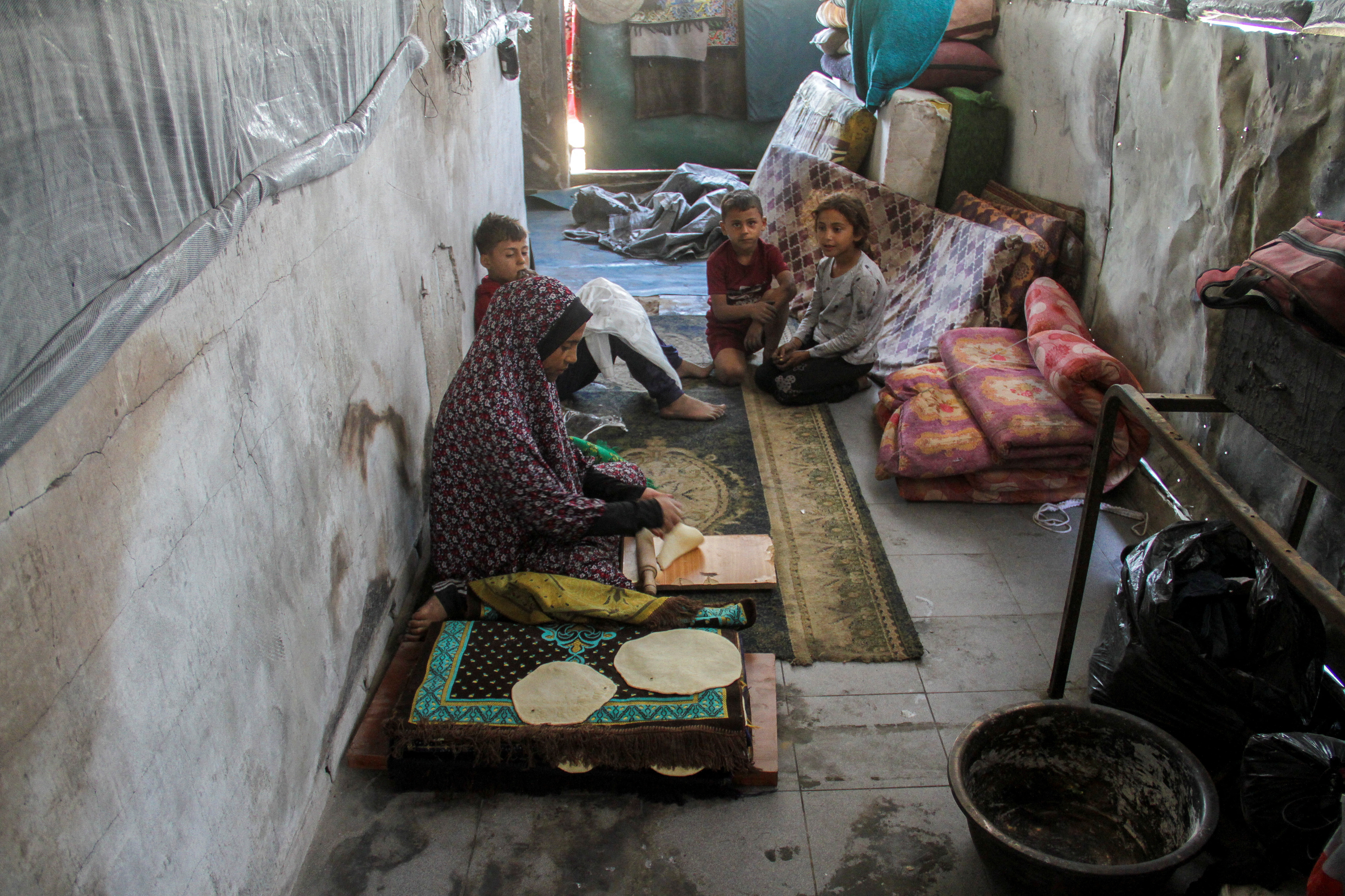 Displaced Palestinian family returns to a damaged school following Israeli raid