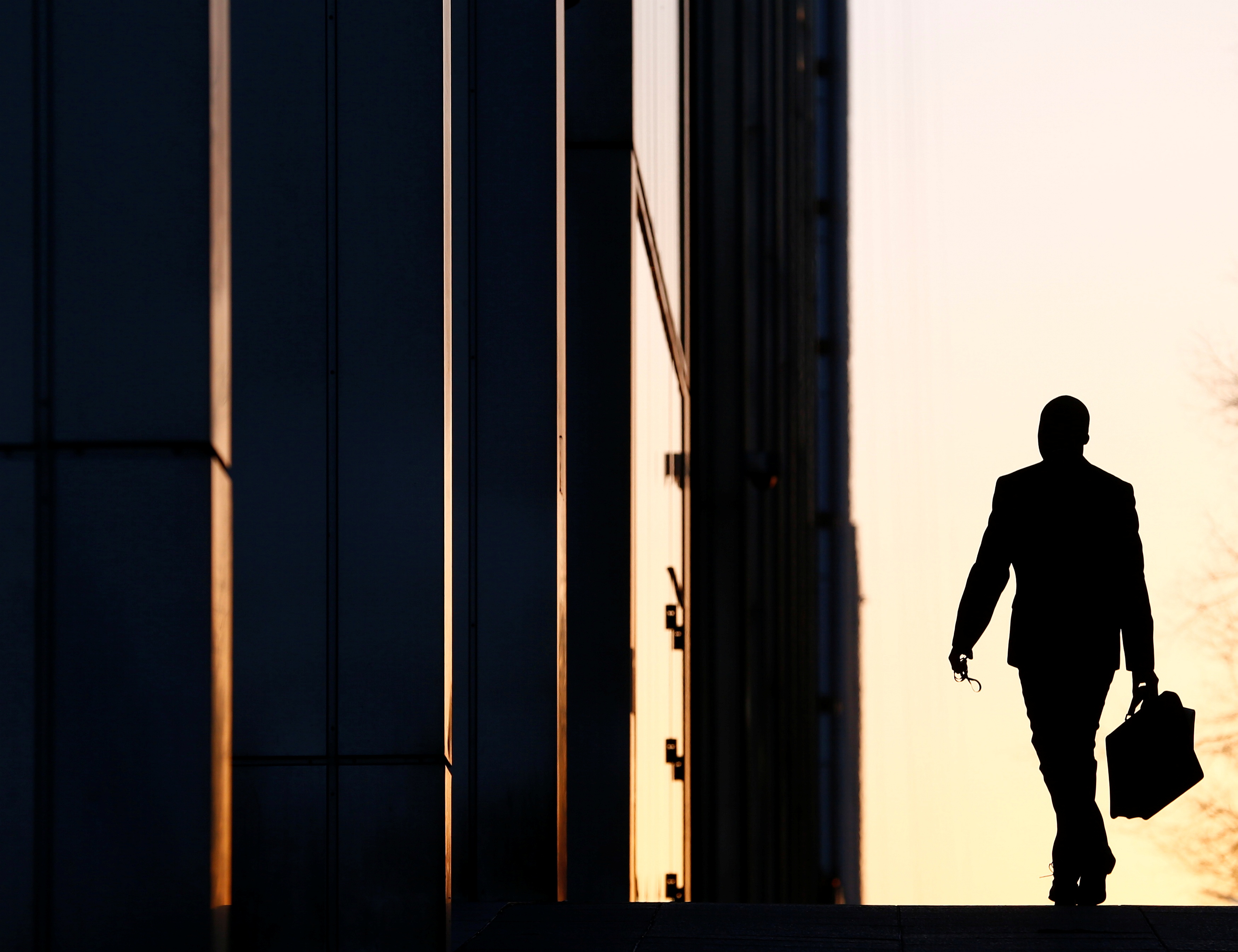 A worker arrives at his office in the Canary Wharf business district in London