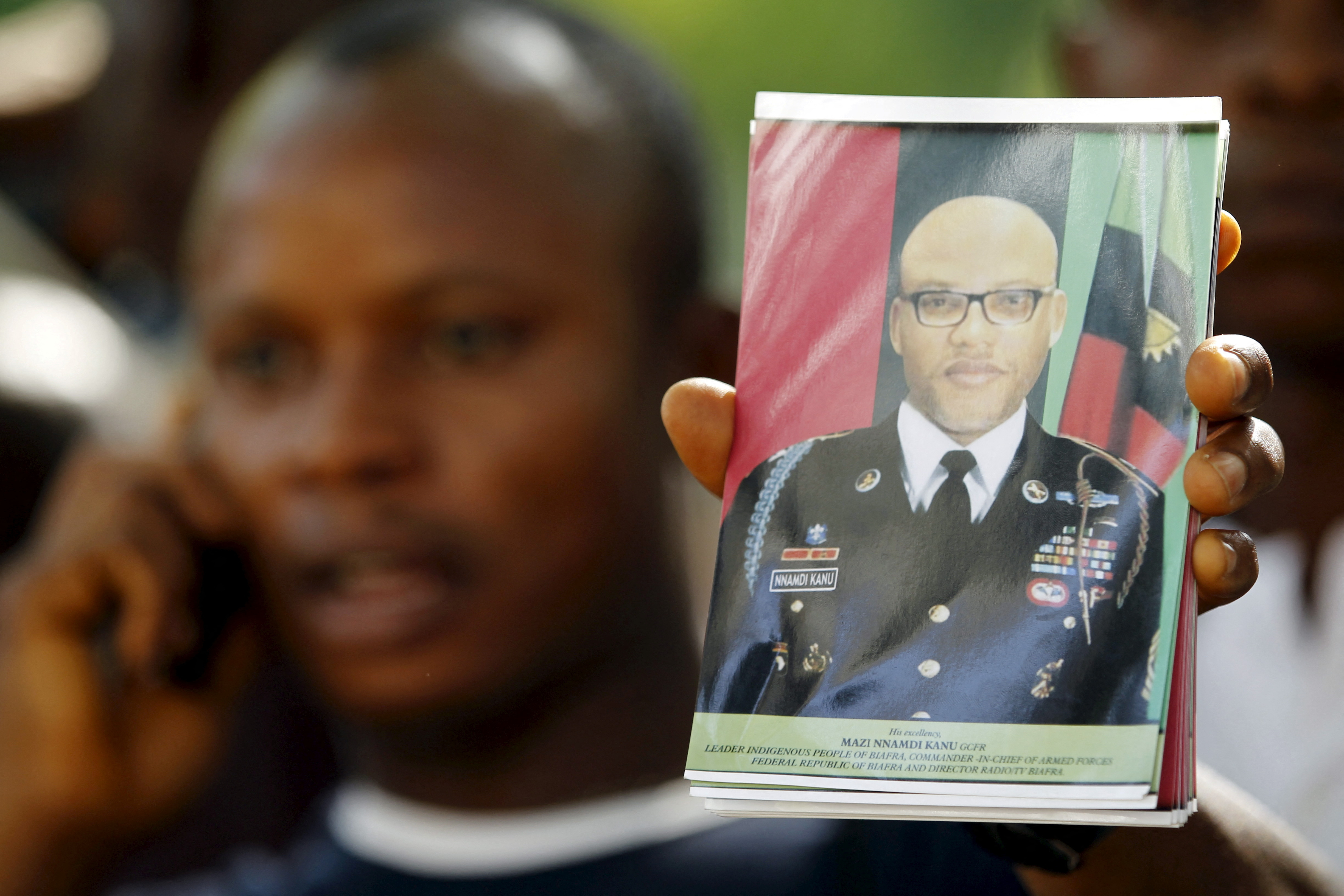 A supporter of Indigenous People of Biafra (IPOB) leader Nnamdi Kanu holds a photograph of Kanu, who is expected to appear at a magistrate court, during a rally in Abuja