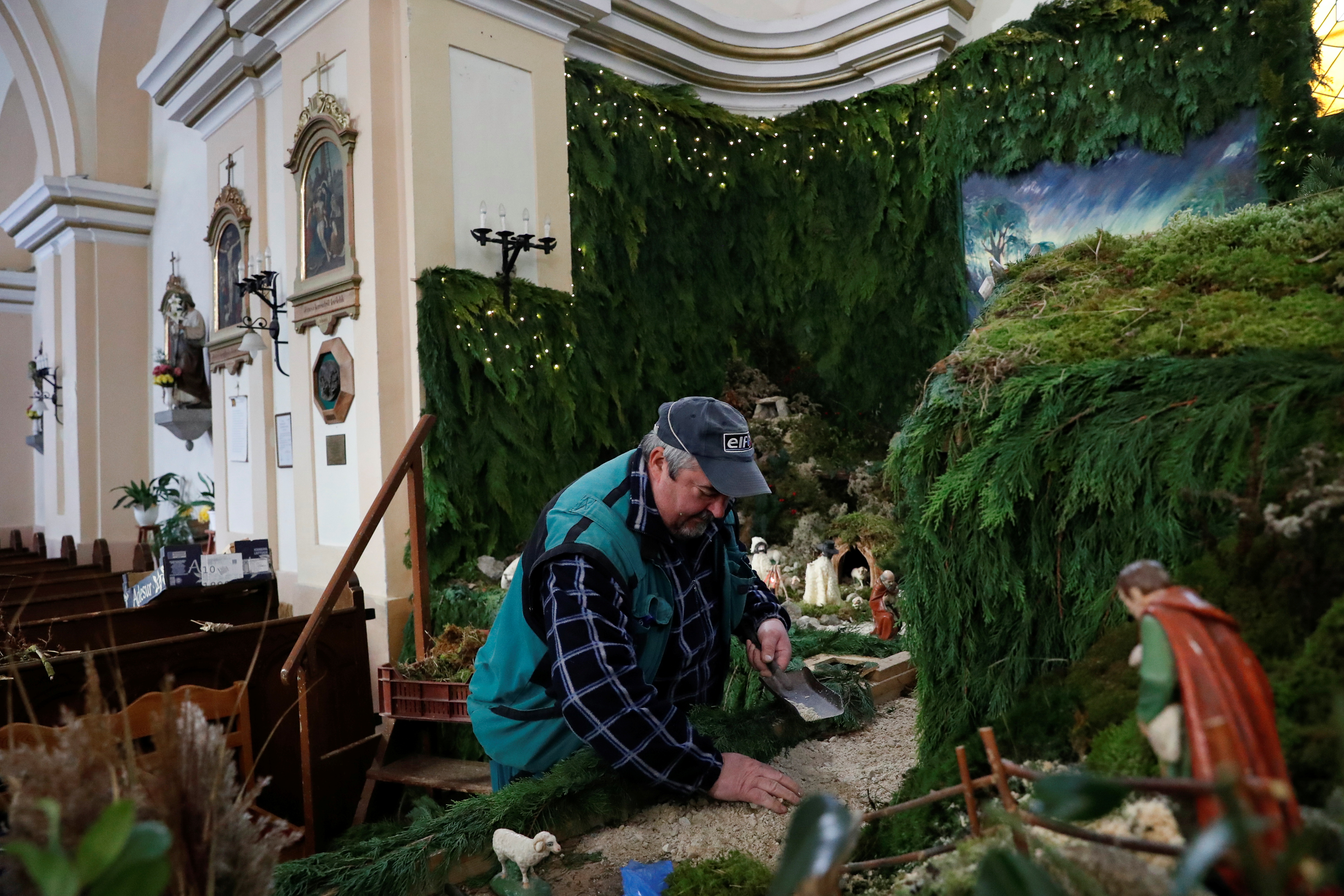 A man prepares one of Europe's largest indoor nativity scenes at the St Martin Church in Vors, Hungary, November 25, 2021. REUTERS/Bernadett Szabo