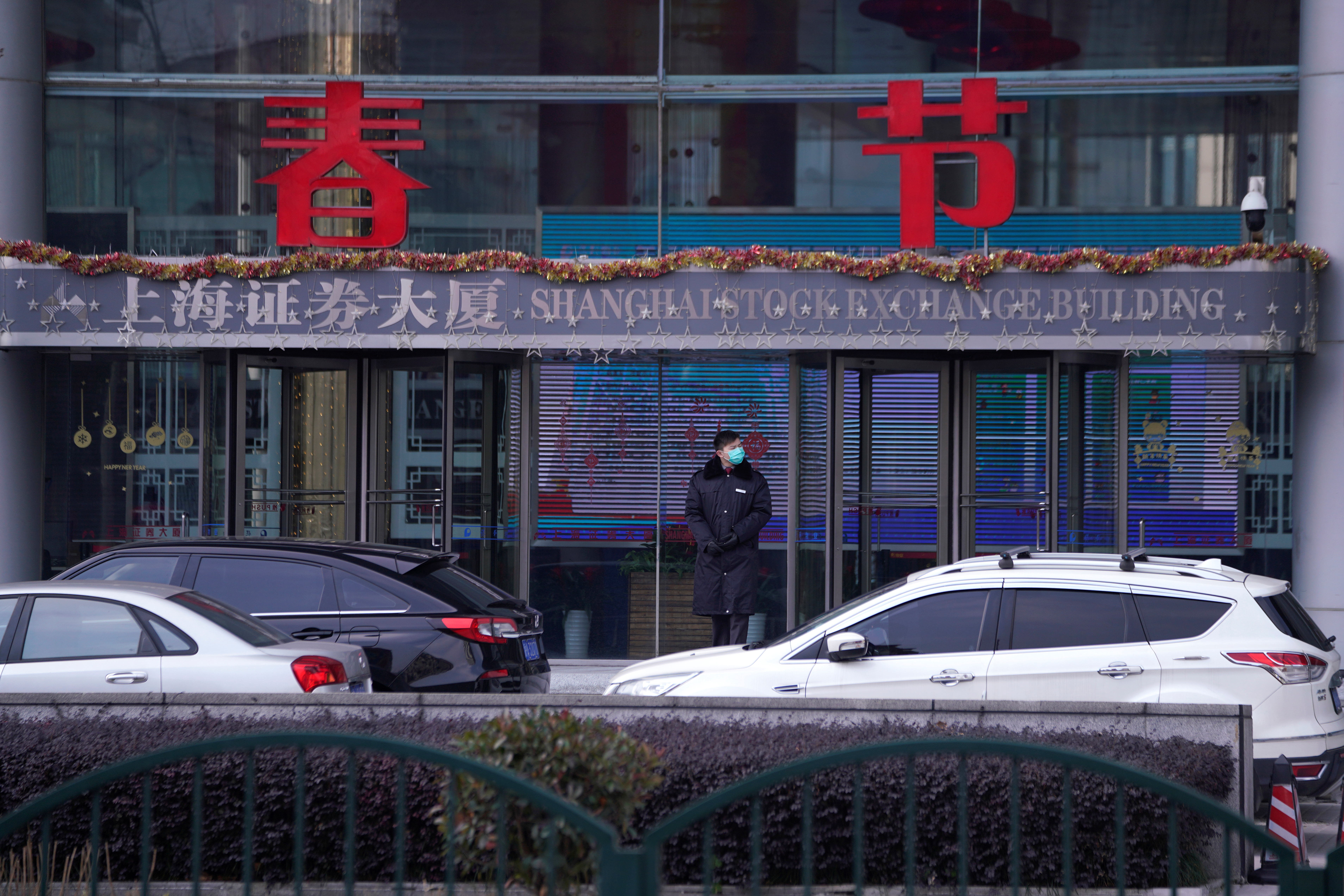 A security guard stands at the Shanghai Stock Exchange building at the Pudong financial district in Shanghai