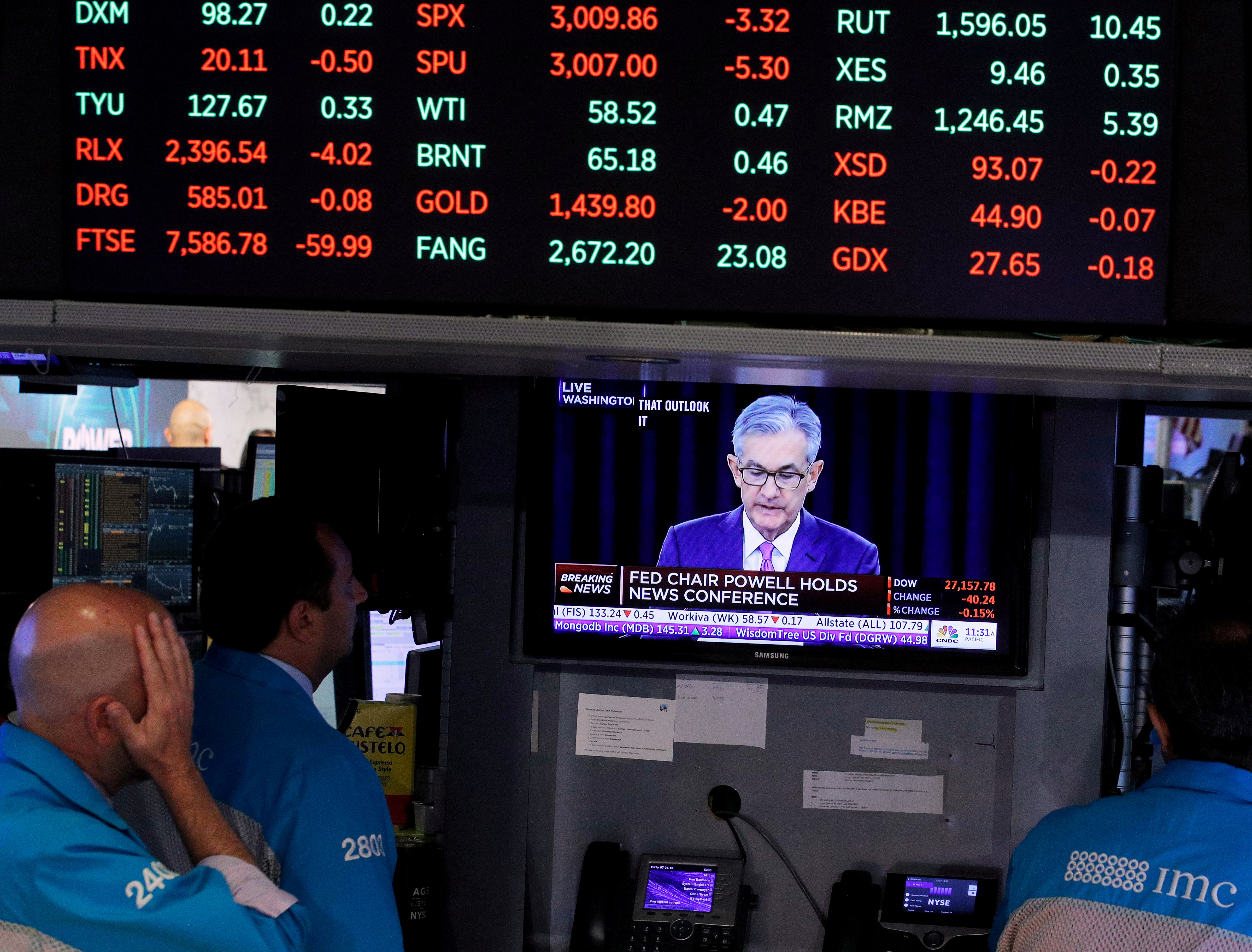 Traders look on as a screen shows Federal Reserve Chairman Jerome Powell's news conference after the U.S. Federal Reserve interest rates announcement on the floor of the New York Stock Exchange (NYSE) in New York, U.S., July 31, 2019. REUTERS/Brendan McDermid/File Photo