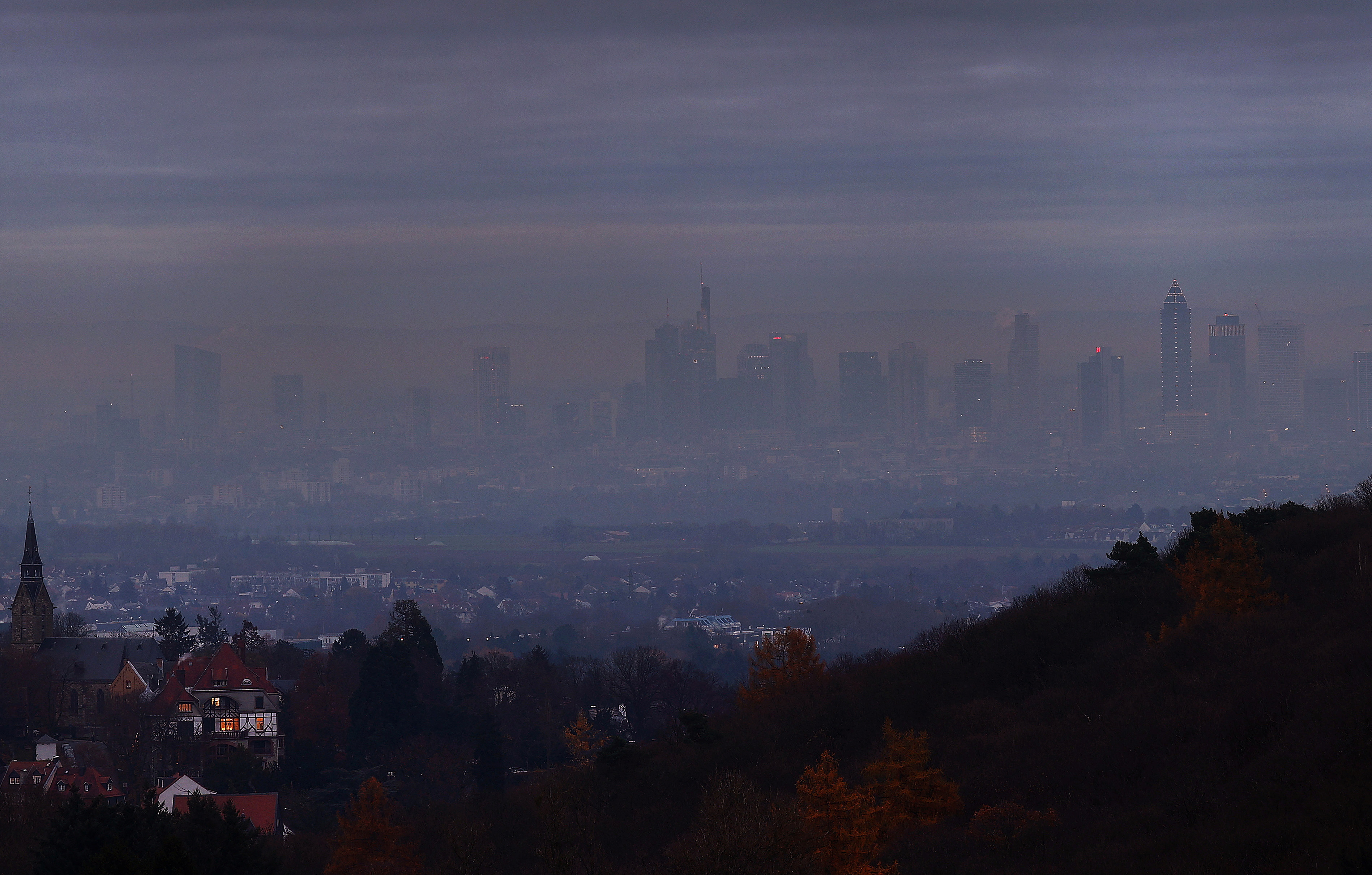 A house is illuminated in front of the skyline of Frankfurt as the spread of the coronavirus disease (COVID-19) continues during a foggy morning in Kronberg, Germany, November 24, 2021.  REUTERS/Kai Pfaffenbach