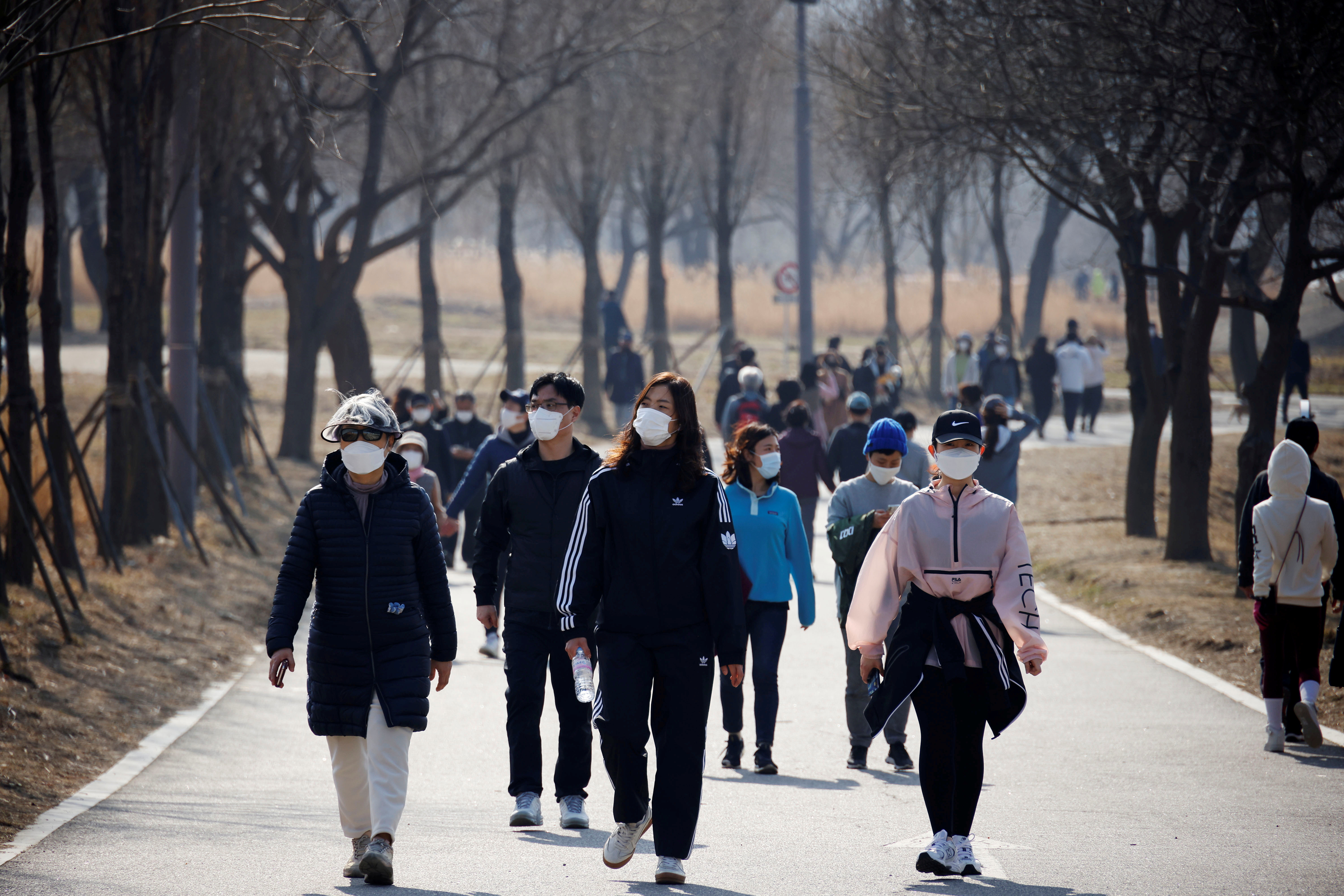 People wearing masks take a walk amid the coronavirus disease (COVID-19) pandemic at a Hanriver Park in Seoul