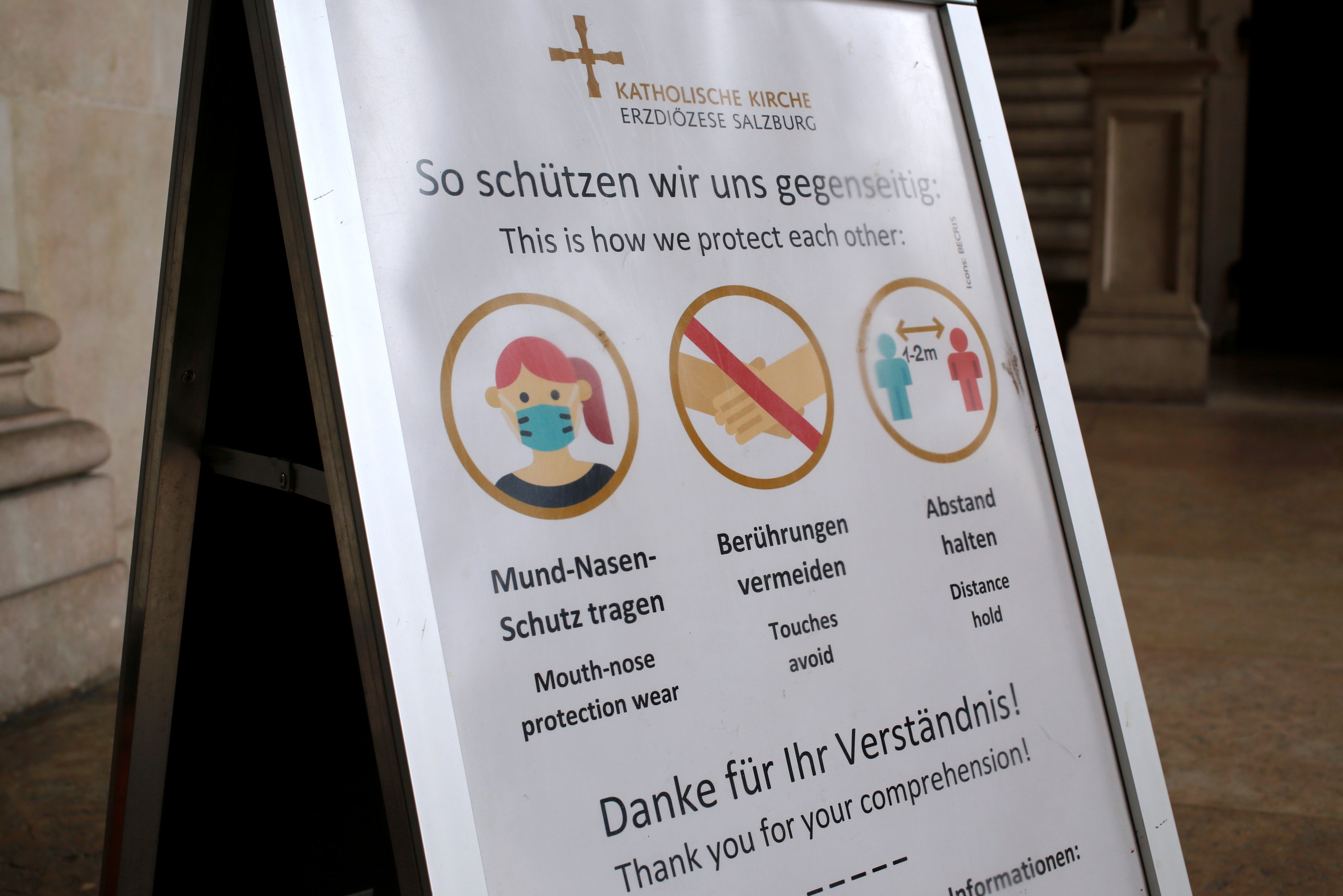 Health protection info sign is seen at a church entrance in Salzburg