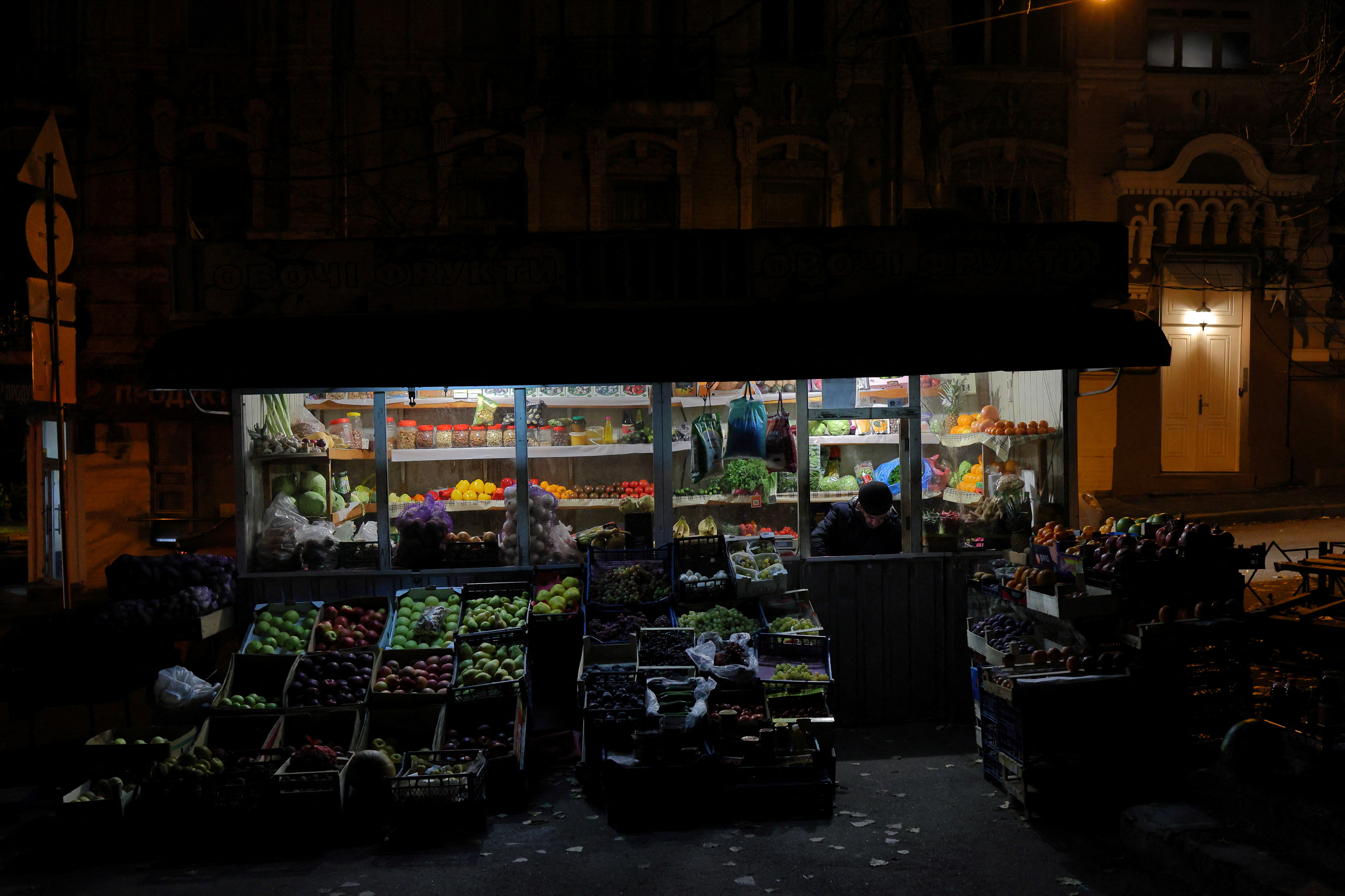 A greengrocer waits for customers at his makeshift shop in Kyiv