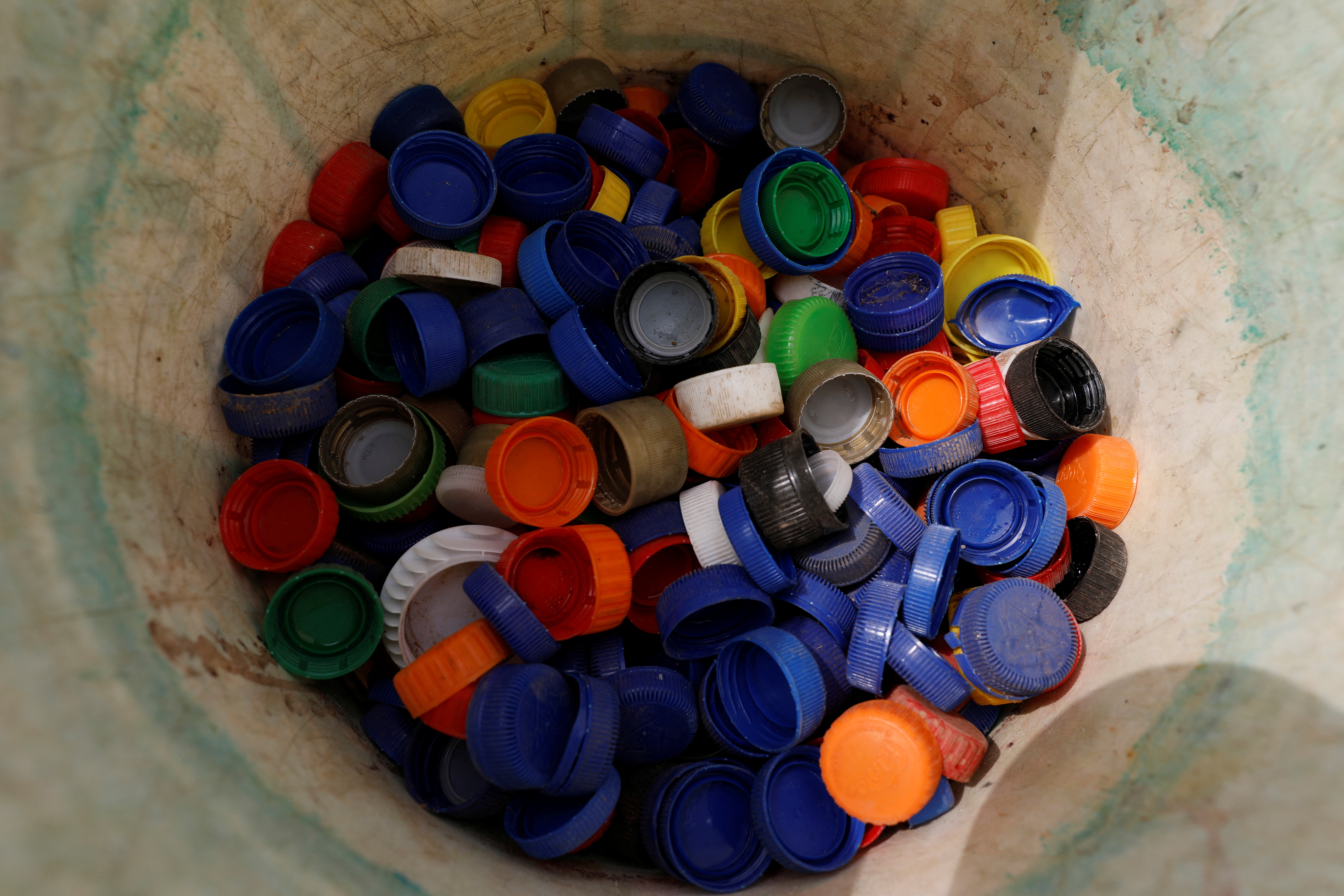 Caps collected from used plastic bottles are stored in a bucket at the Waste museum in Ibadan