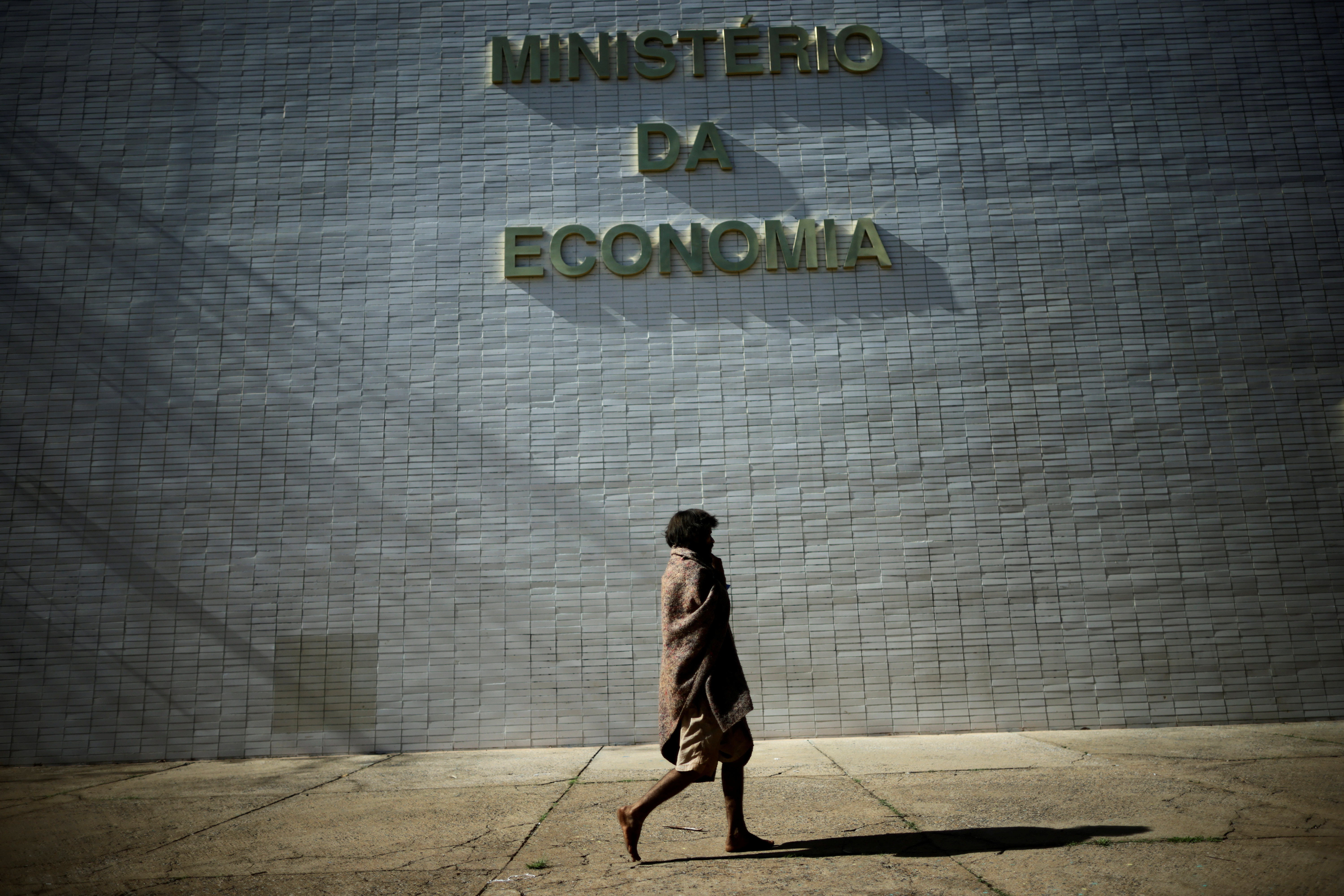 A homeless walks near the Ministry of the Economy building in Brasilia