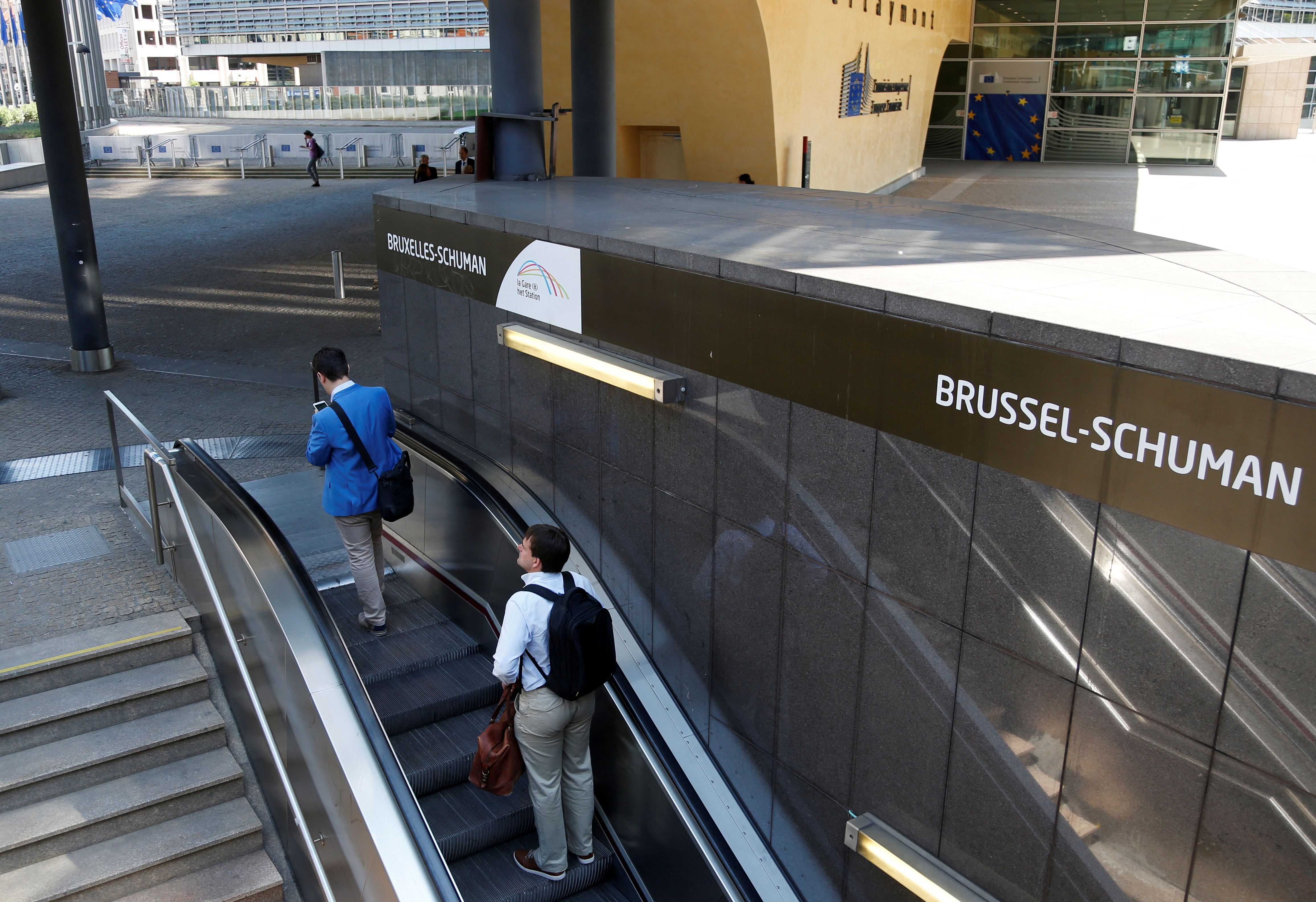 Commuters exit Brussels-Schuman underground station in front of the European Commission headquarters in Brussels