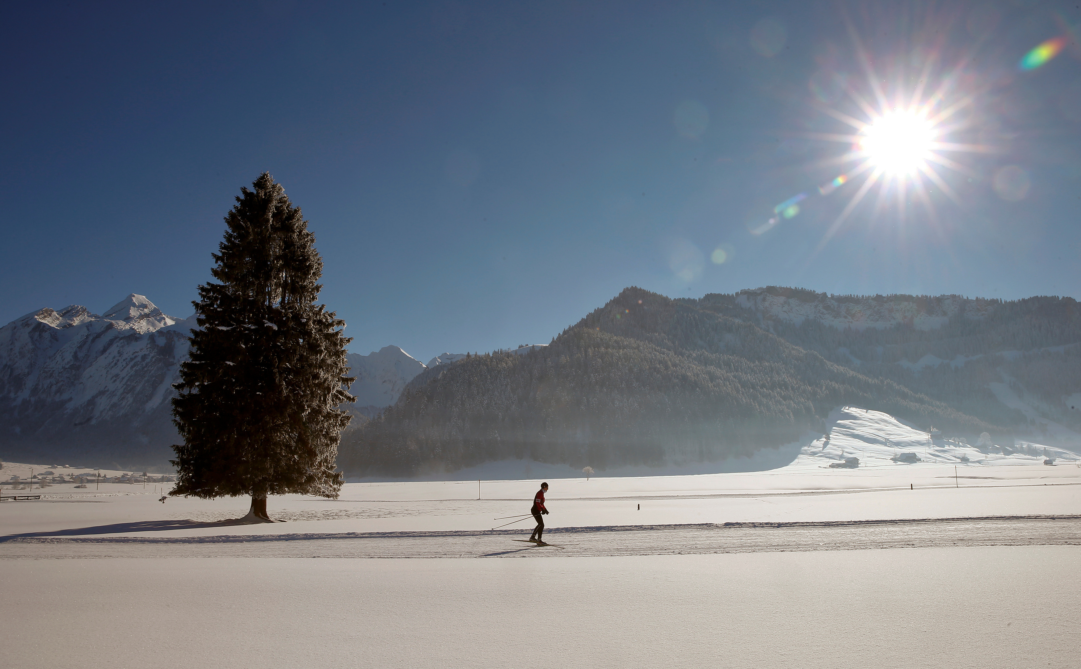 A cross-country skier is seen in the snow-covered landscape near Unteriberg